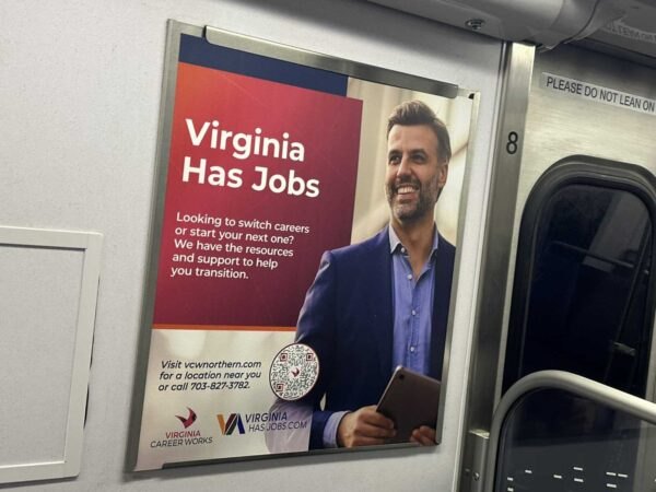 Transit advertisement inside a Metro car promoting Virginia job resources, featuring a man holding a tablet.