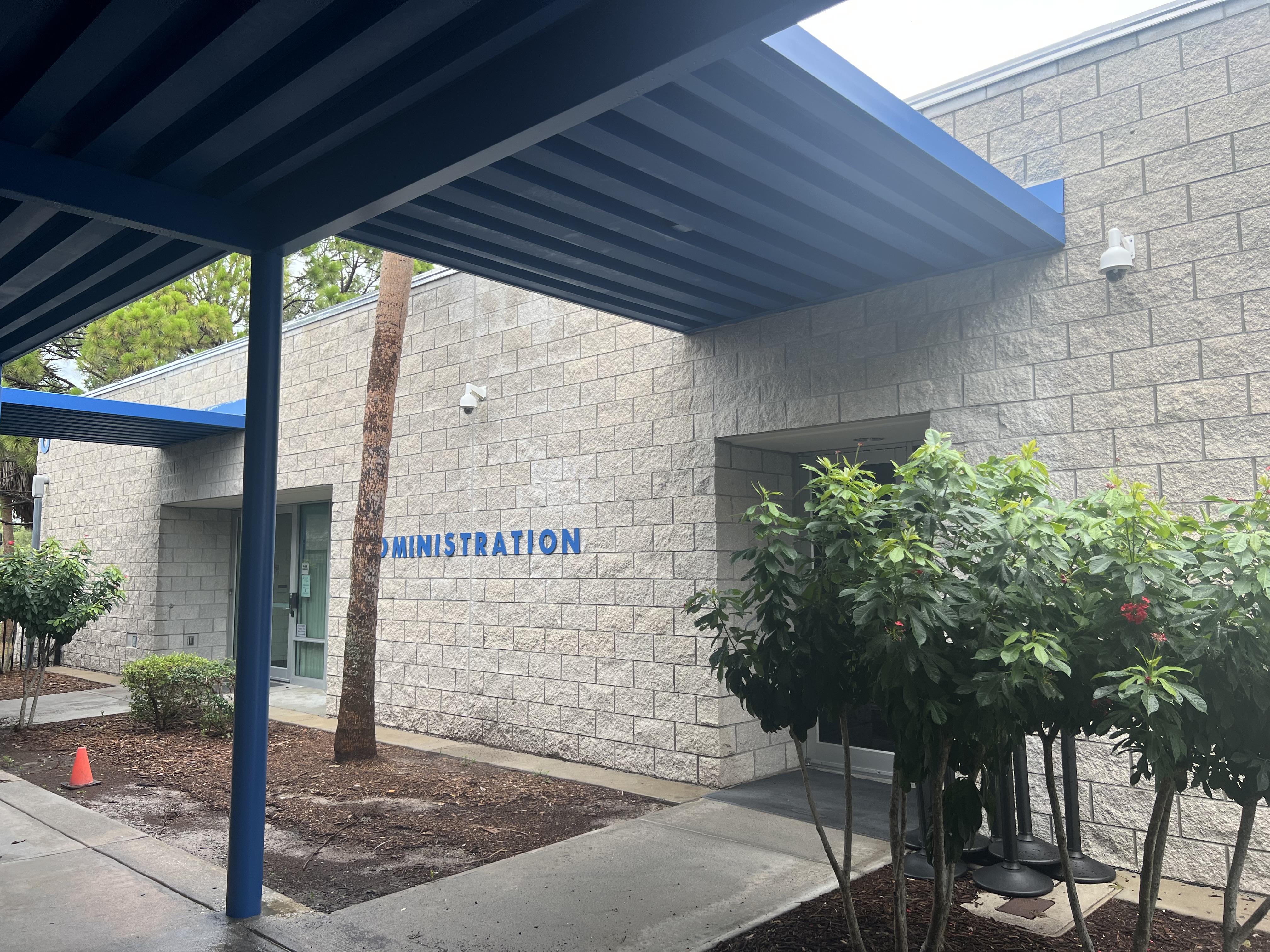 School administration building with stone exterior and blue 'ADMINISTRATION' sign.