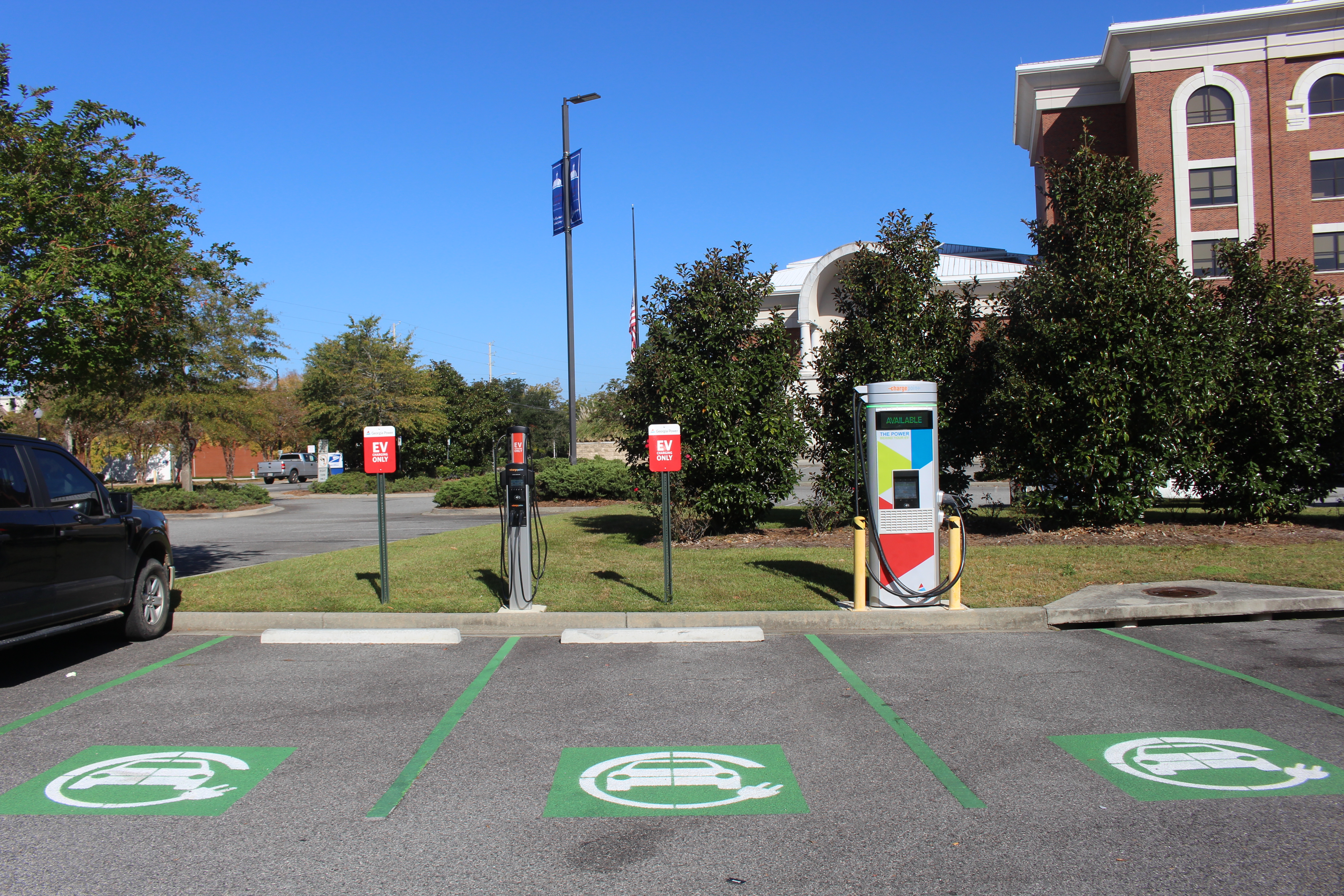 ChargePoint electric vehicle charger with green EV parking markings in a lot.