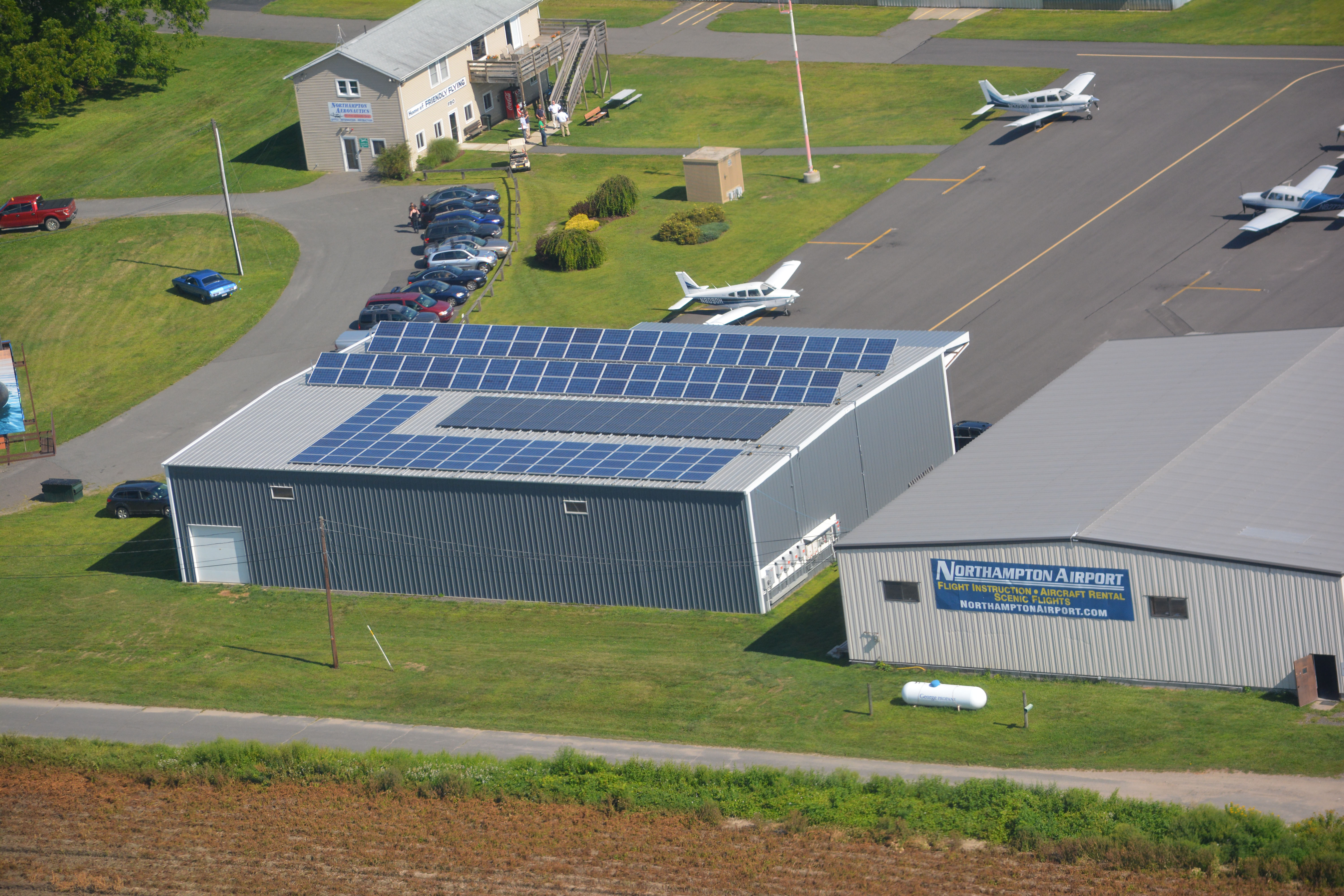 Aerial view of a building rooftop covered with rows of solar panels.
