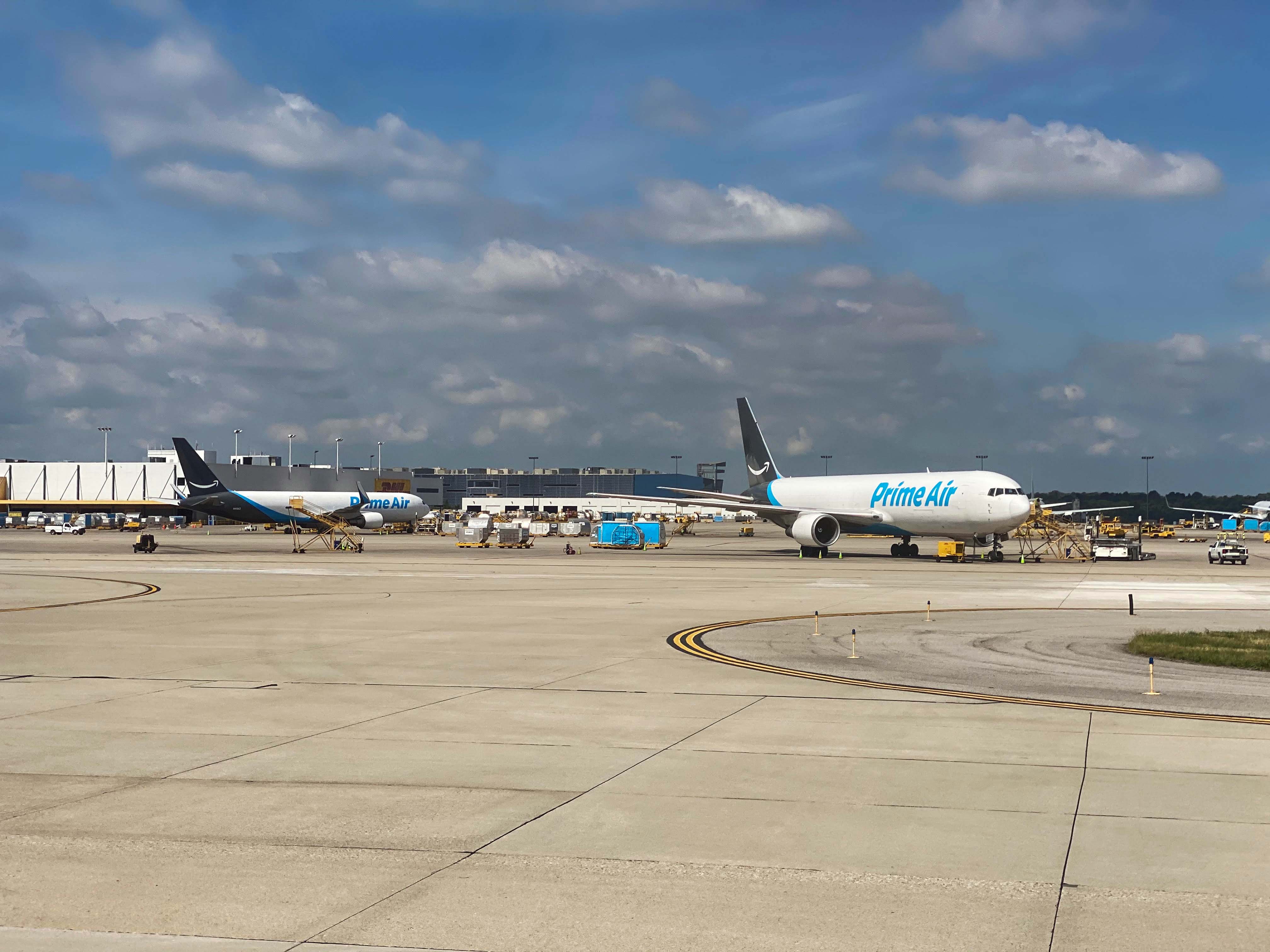 White Amazon Prime Air Boeing 767 cargo jet parked on an airport ramp.