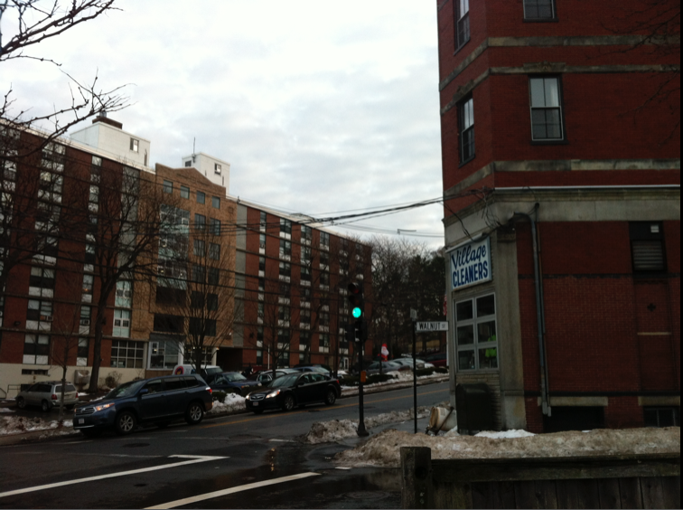 Large brick apartment buildings at a snowy street corner in Brookline, Massachusetts.