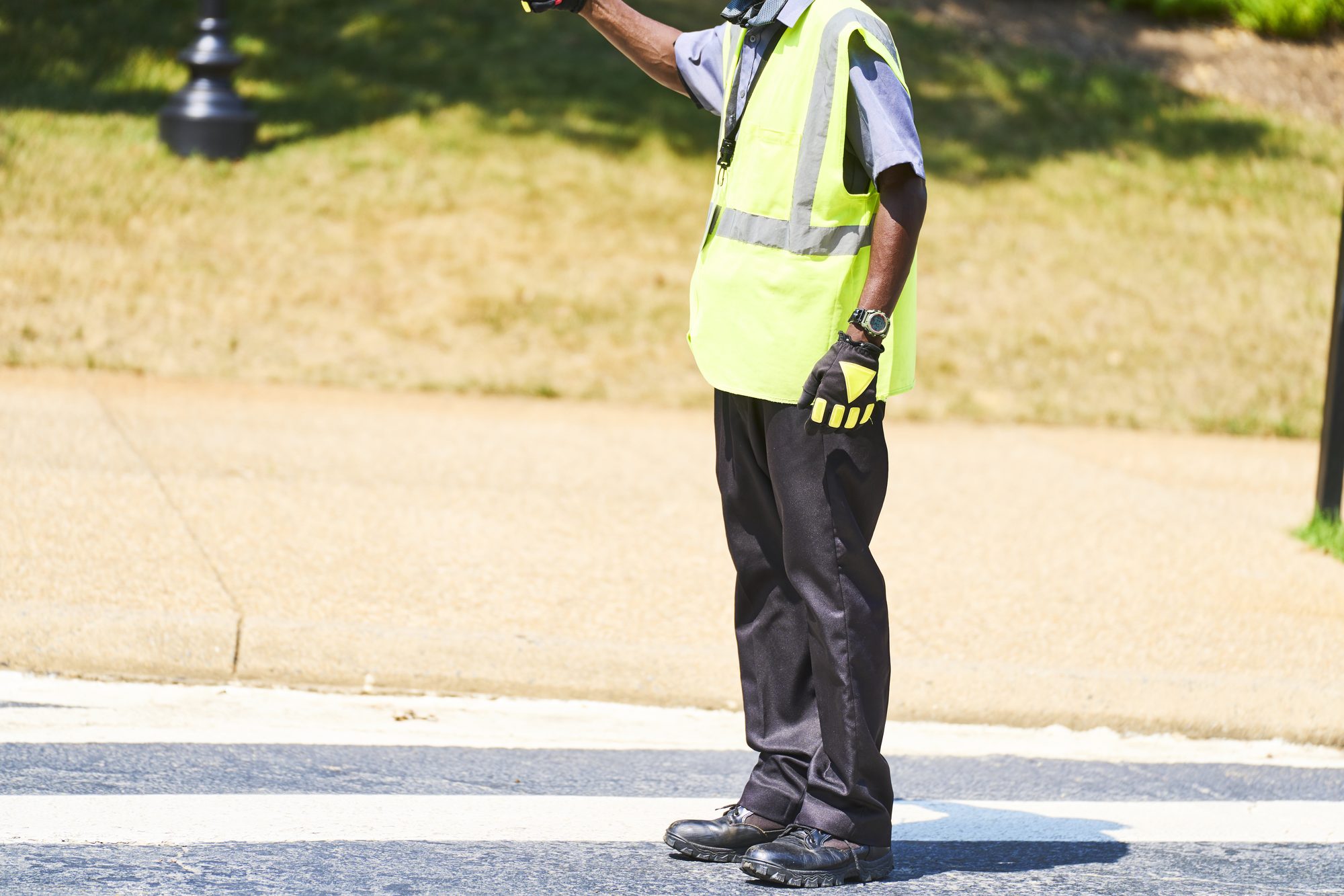 Crossing guard directing traffic on a sunny day