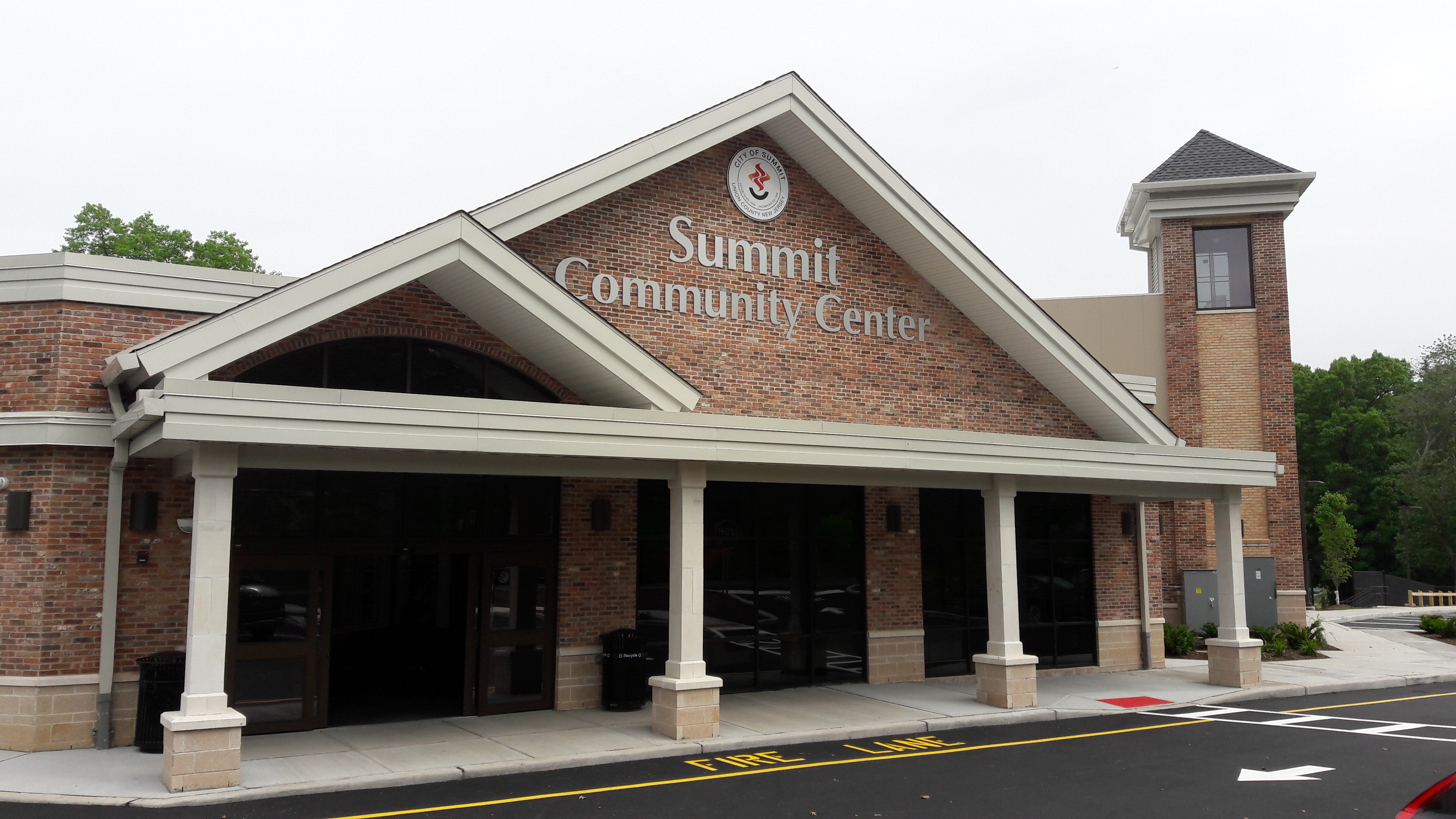 Exterior of a brick community center with a white-columned entrance and a sign reading Summit Community Center.