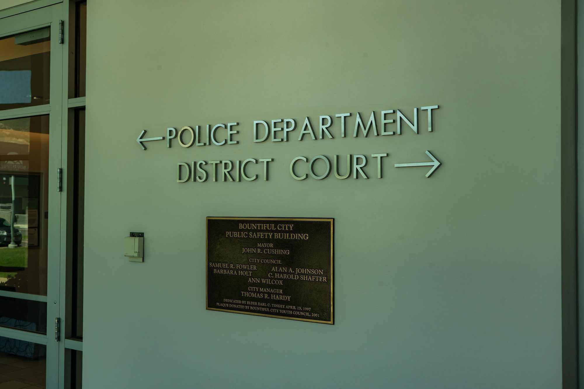 Wall signs with arrows directing visitors to police department and district court entrances.
