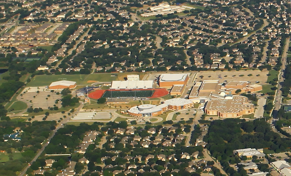 Aerial view of Flower Mound High School campus with football stadium and parking lots.