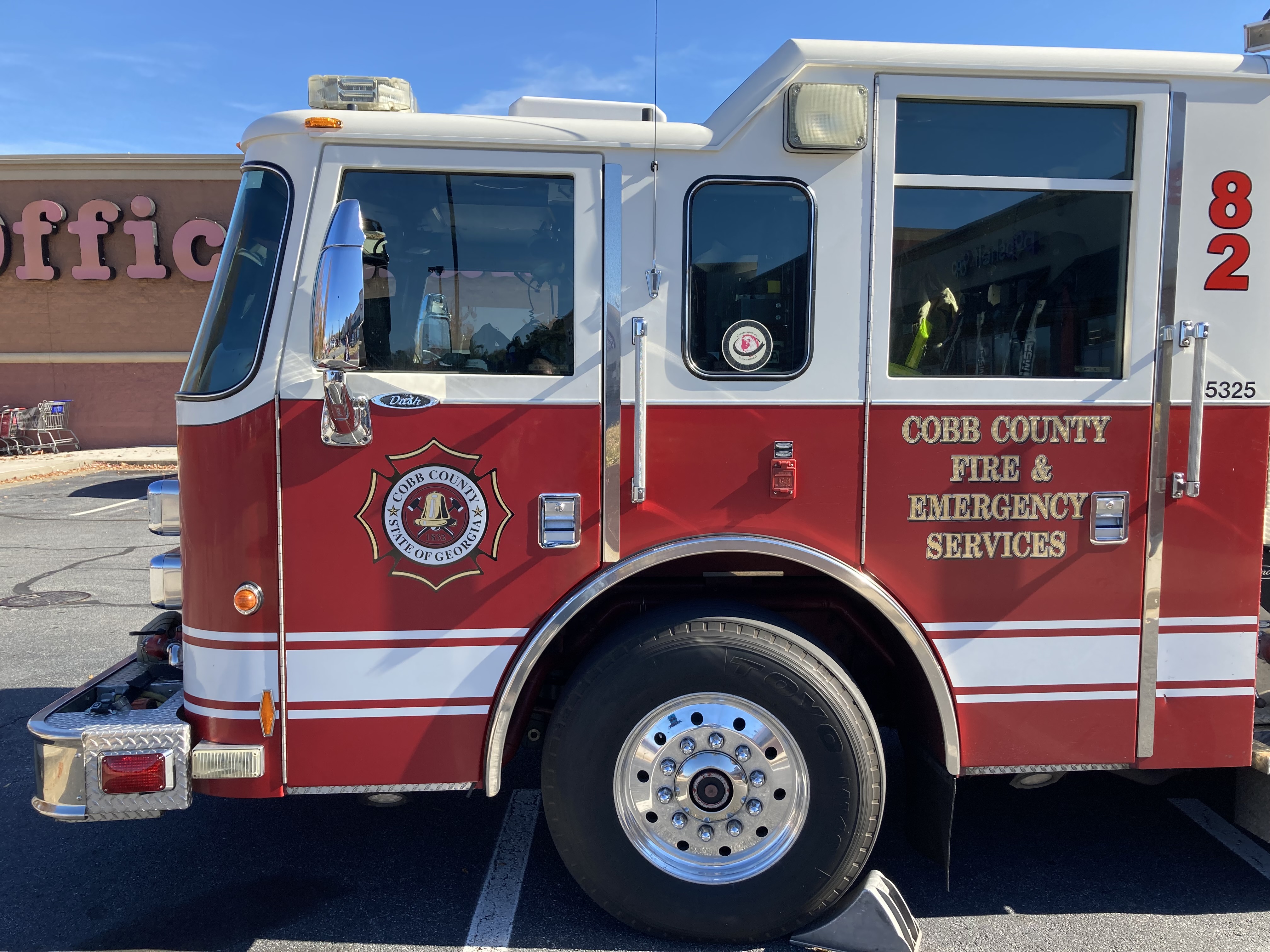 Close-up of the driver-side cab of a red Cobb County fire department engine.