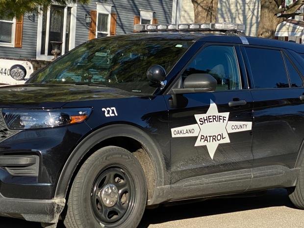 Dark blue Oakland County Sheriff Patrol SUV parked on a residential street.