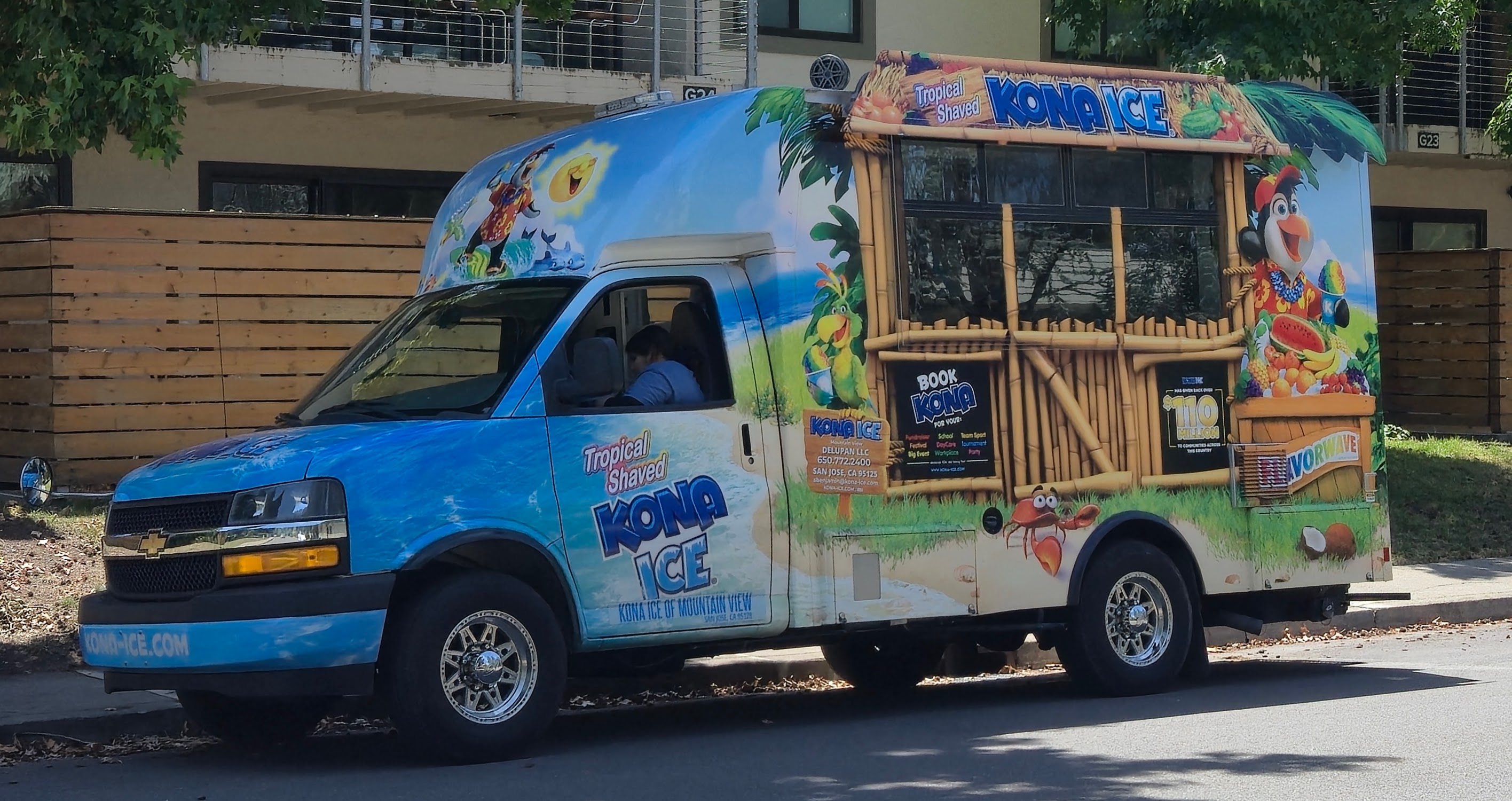 A colorfully wrapped Kona Ice shaved ice truck parked on a street.