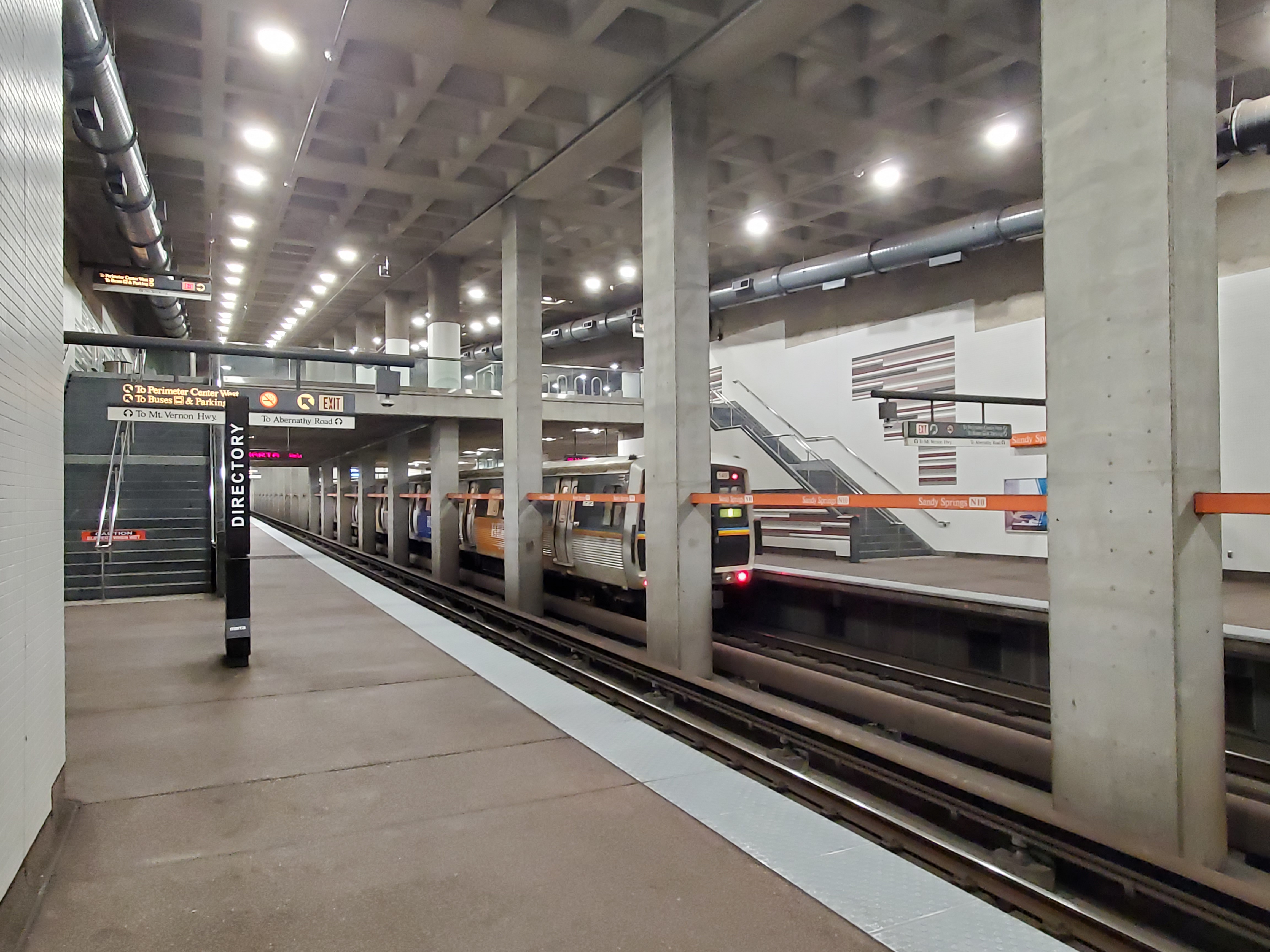 MARTA train arriving at an underground station platform with concrete columns and overhead lighting.