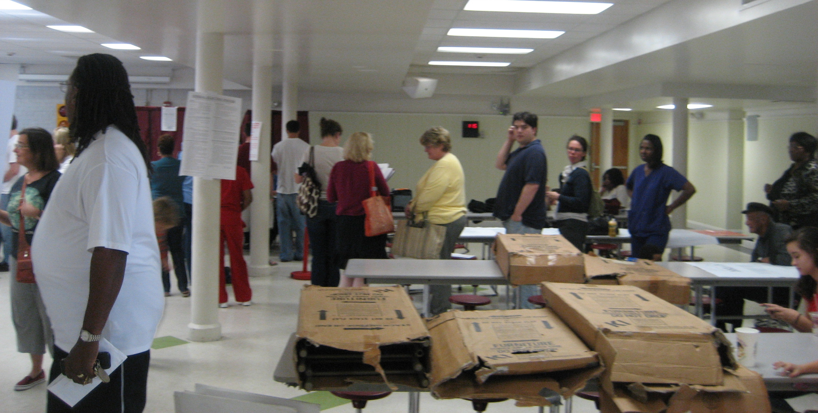 Voters standing in lines inside a school building used as a polling precinct.