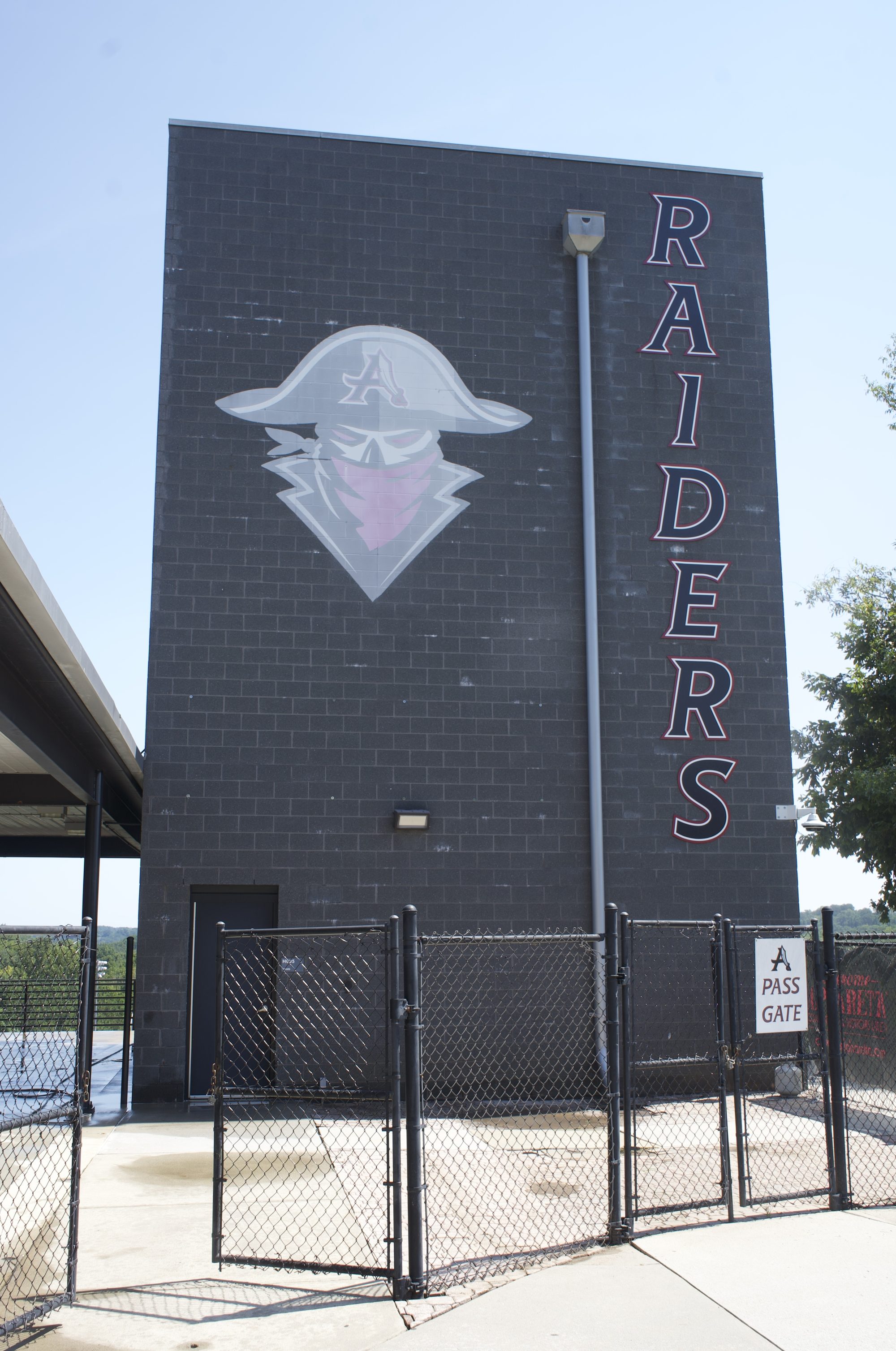 Brick school wall painted with a pirate mascot mural and Raiders lettering