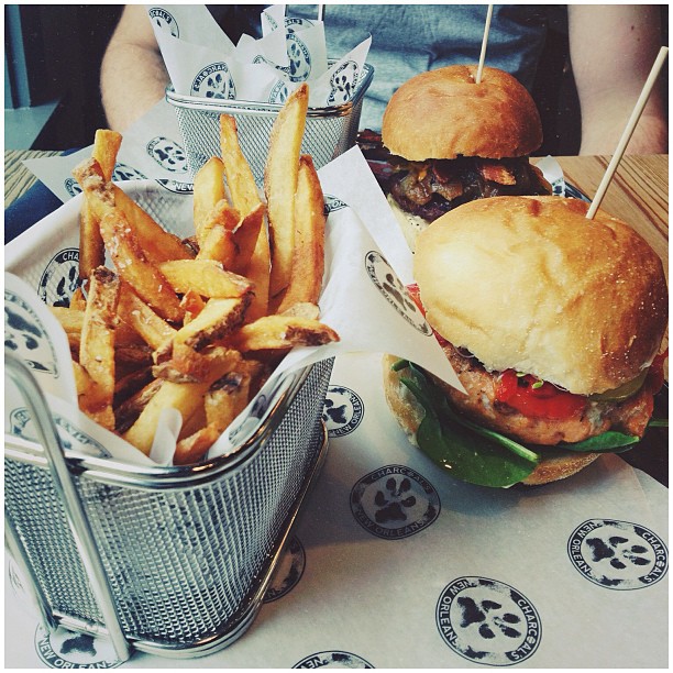 Two burgers and a basket of fries on a branded paper-lined table.