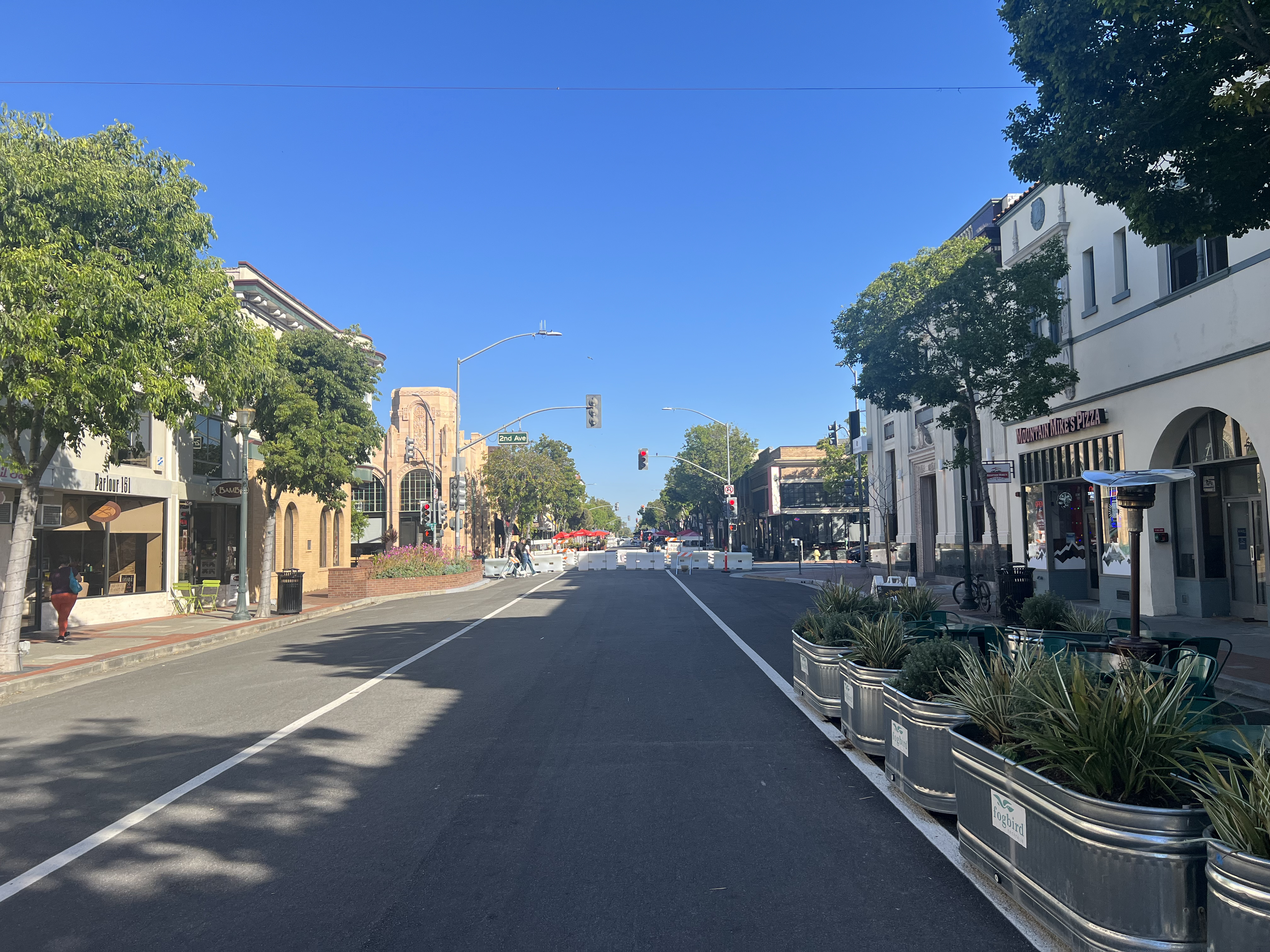 Sunny daytime view of B Street in San Mateo lined with storefronts and street trees.