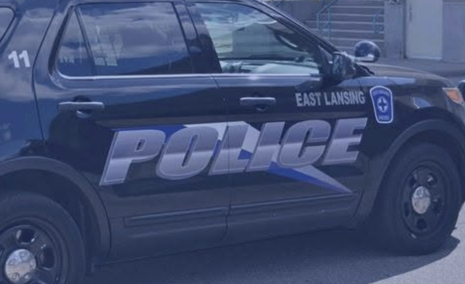 Close-up of the East Lansing Police Department logo on the door of a marked patrol vehicle.