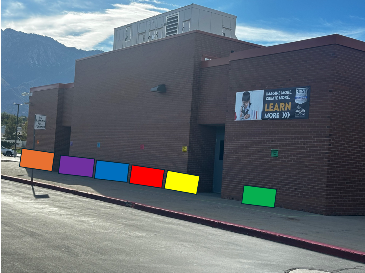 Brick elementary school building with mountains in the background and a motivational sign on the facade.