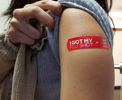 A young woman shows off her flu shot after receiving vaccine at a local drug store.
Other information
Cropped from the original