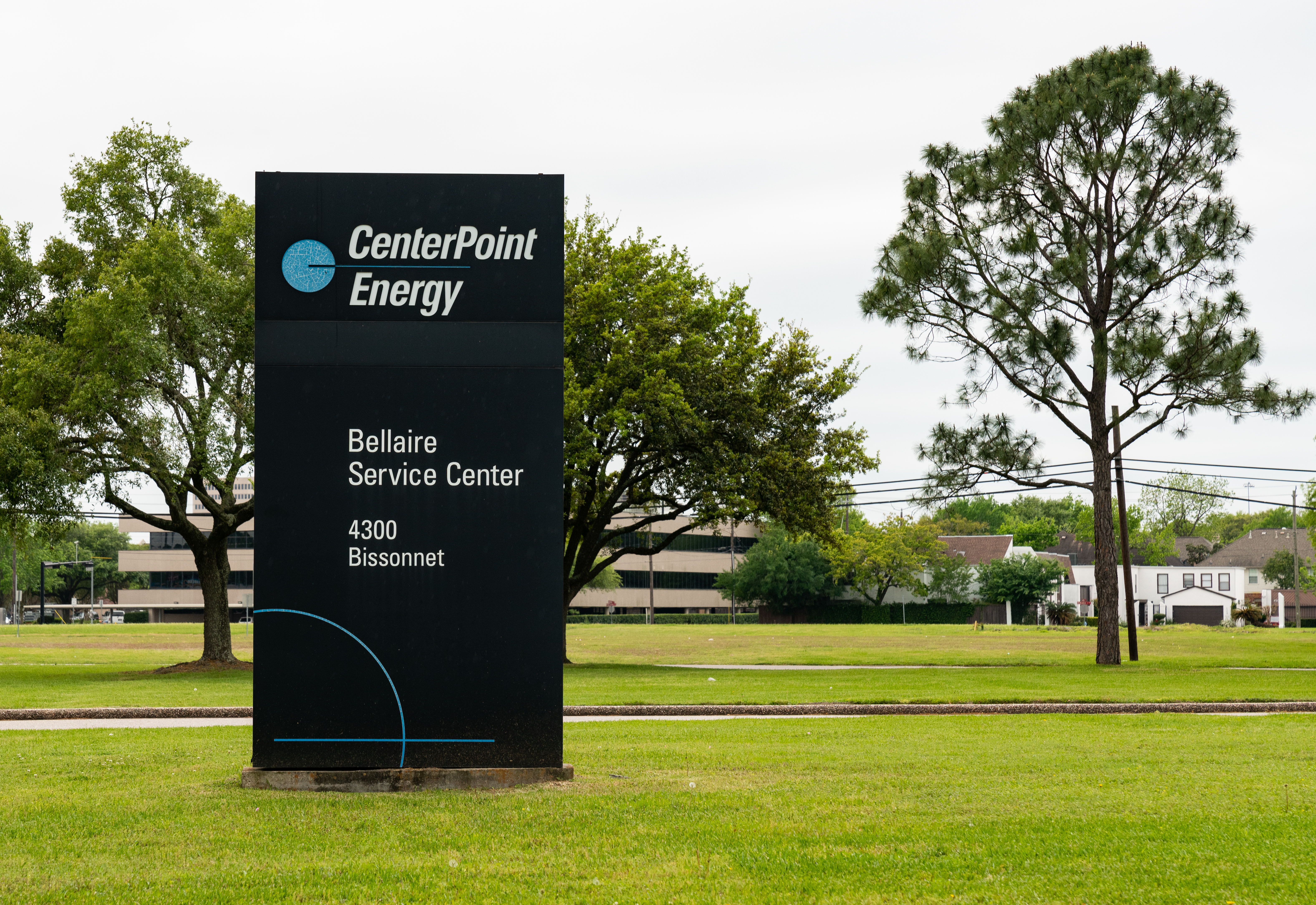 CenterPoint Energy facility sign on a green lawn with trees behind it.