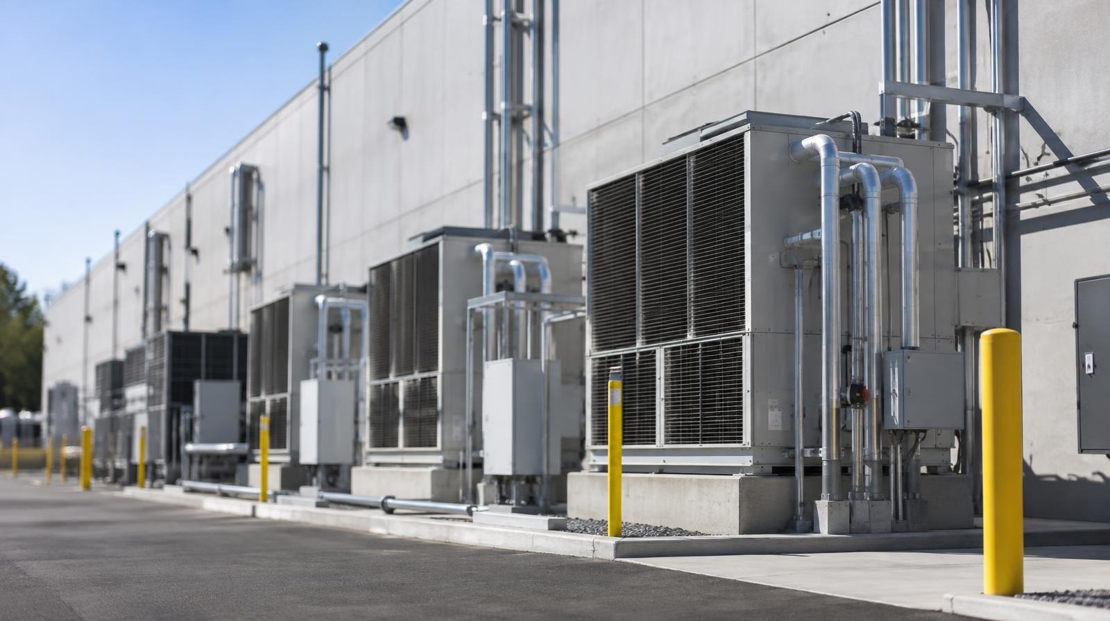 Large modern data center building exterior with rows of ventilation and cooling units.