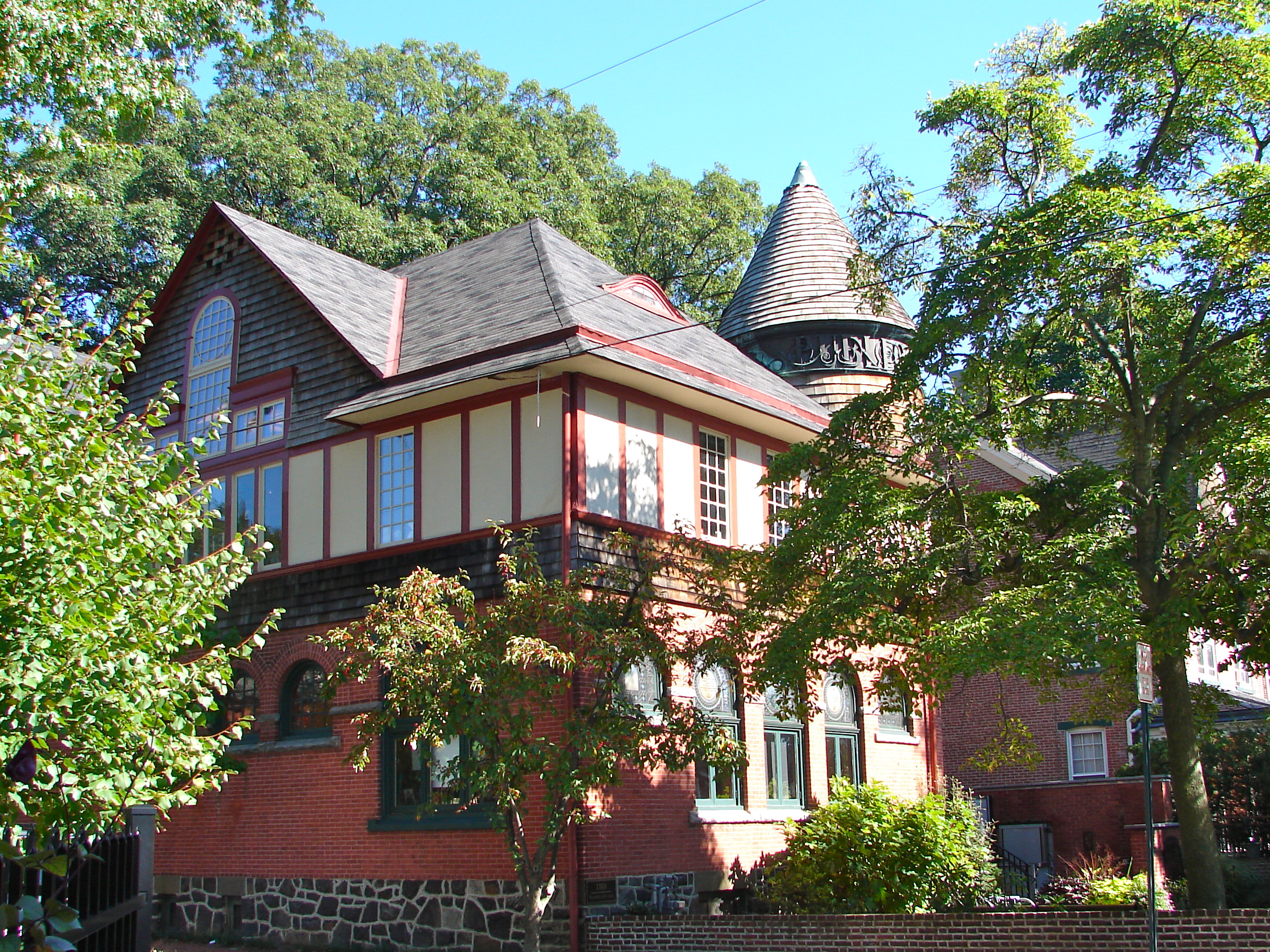 Victorian stone library building with a conical tower and 'Public Library' lettering.
