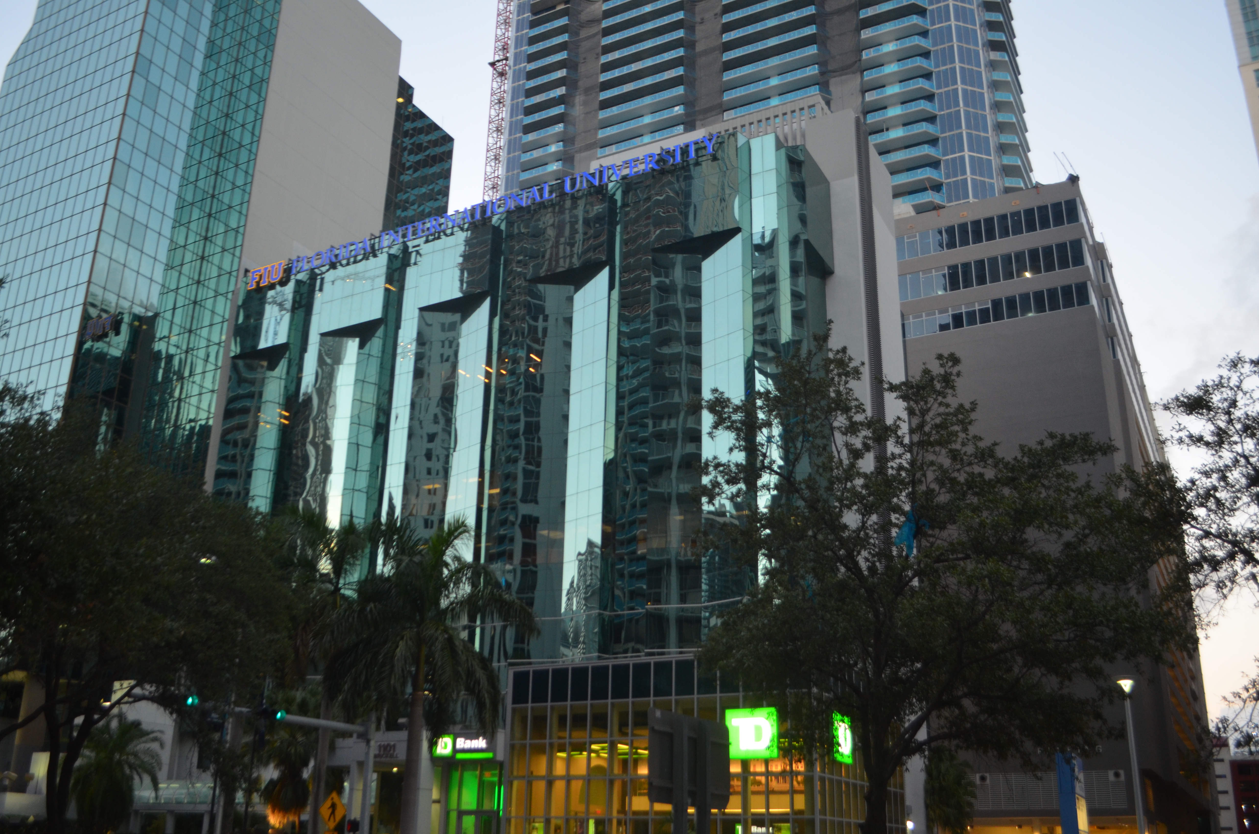 Glass-facade building with Florida International University signage at dusk in downtown Miami.