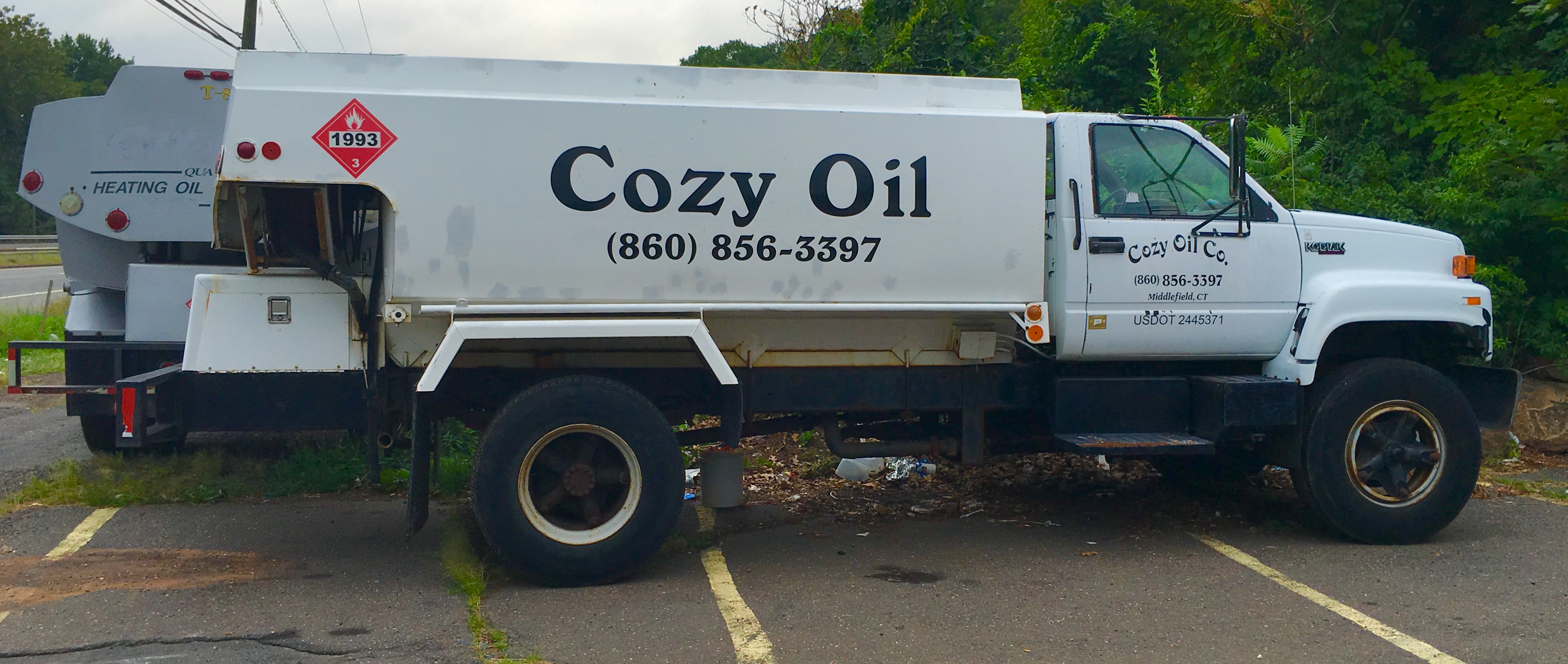 White tanker truck labeled heating oil parked outdoors.