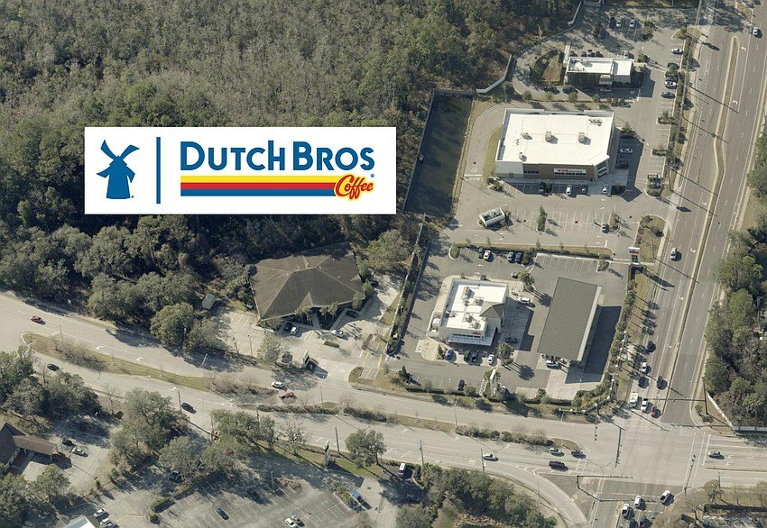 Aerial view of a commercial intersection with parking lots and buildings.