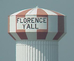 A striped water tower reading 'Florence Y'All' against a clear sky.