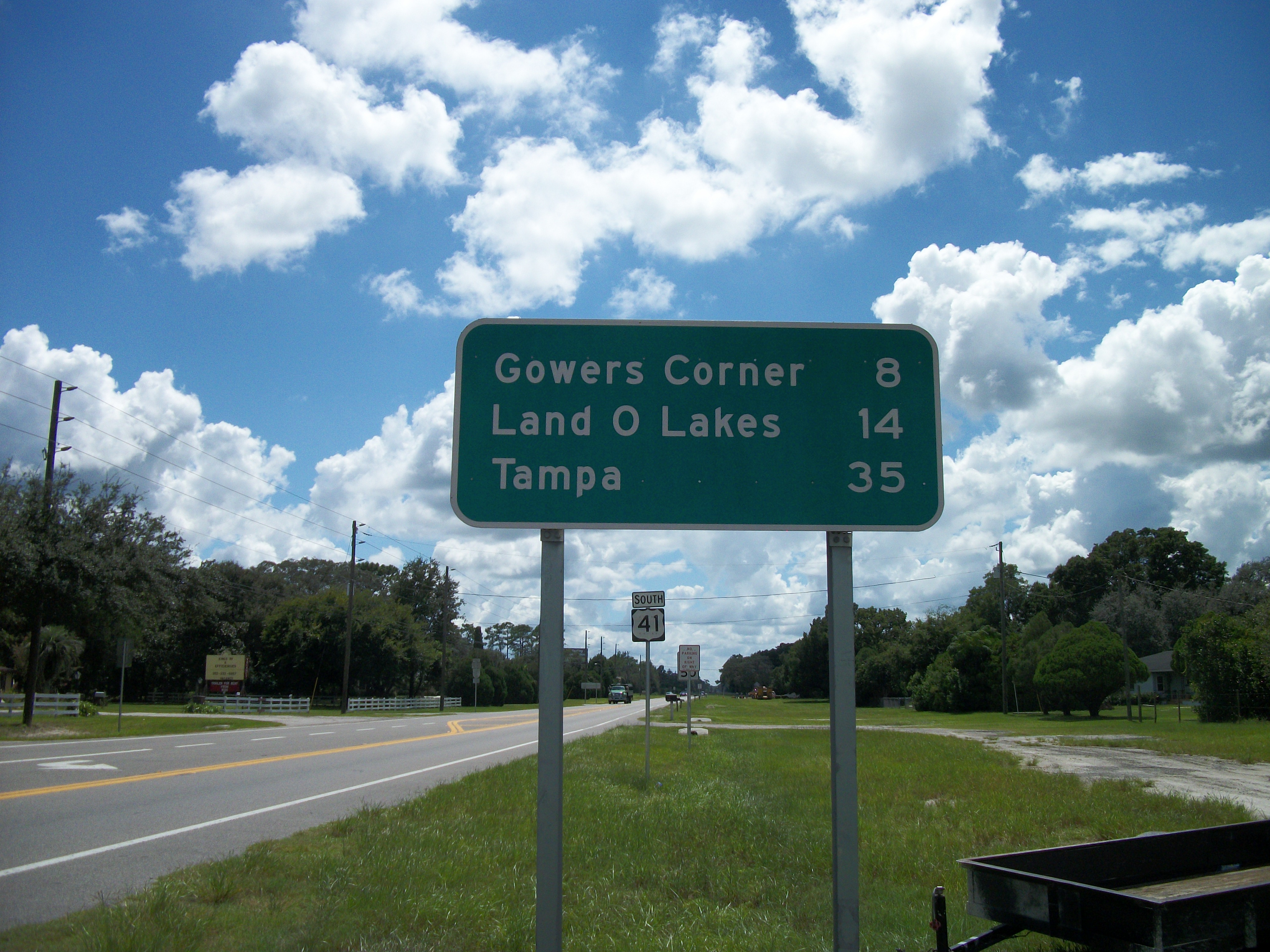 Green highway sign on U.S. 41 showing distance to Land O' Lakes, Florida.