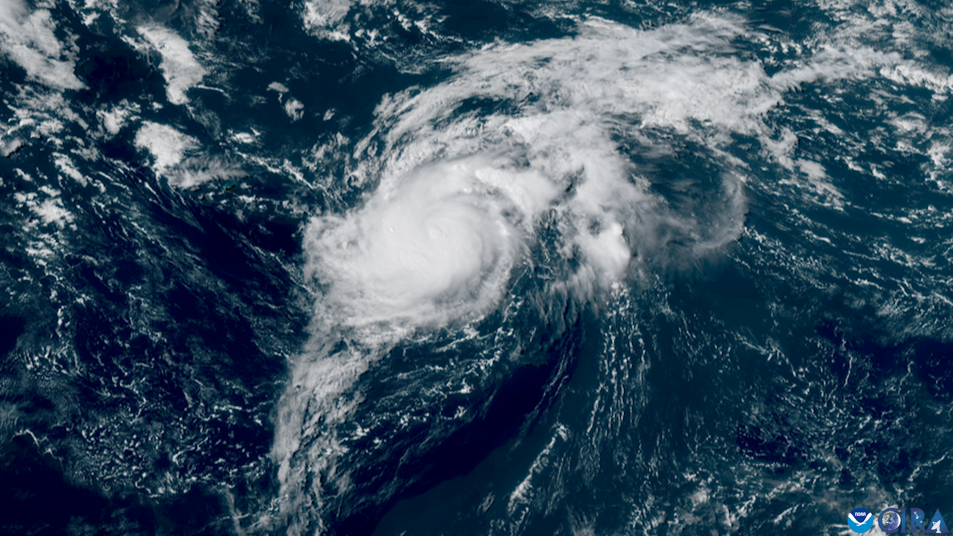 Satellite view of a tropical storm with a visible eye over the open Atlantic.