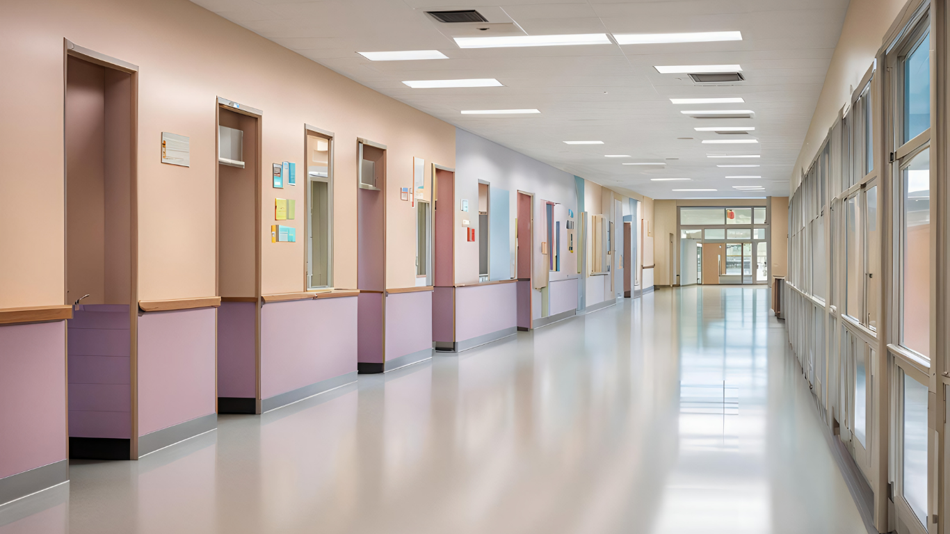 Lights on in empty school hallway.