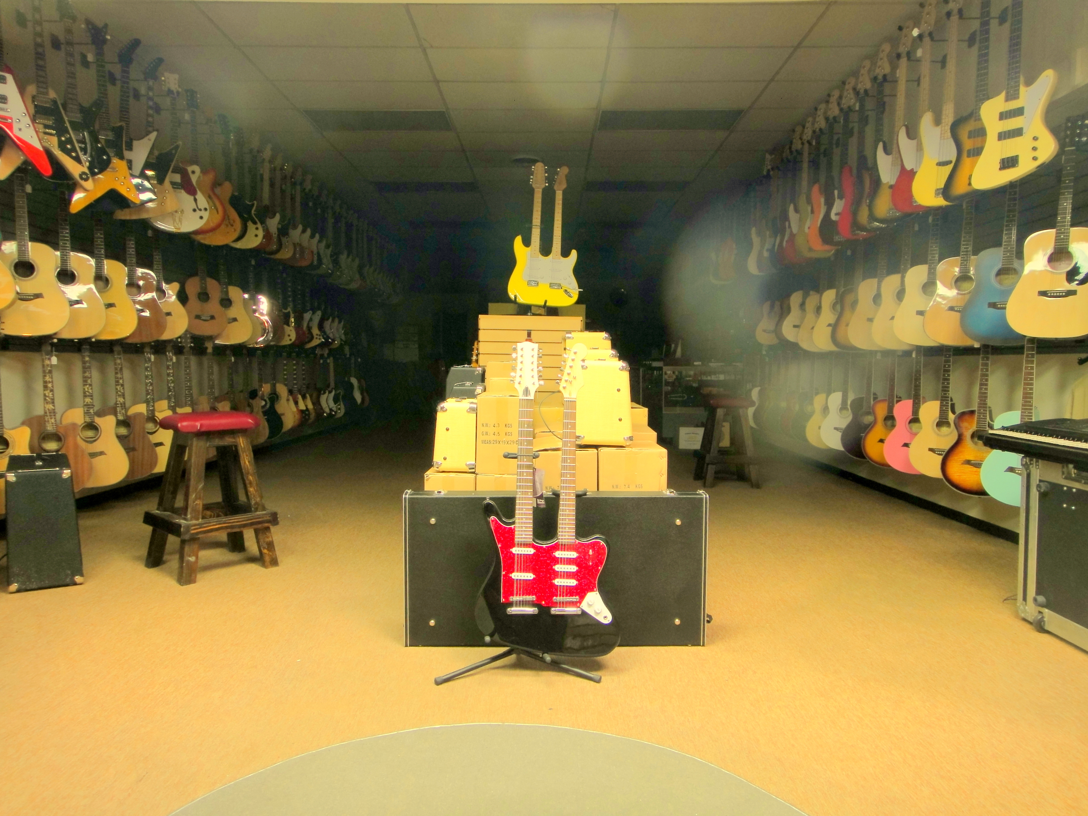 Rows of acoustic and electric guitars displayed on walls inside a music store.