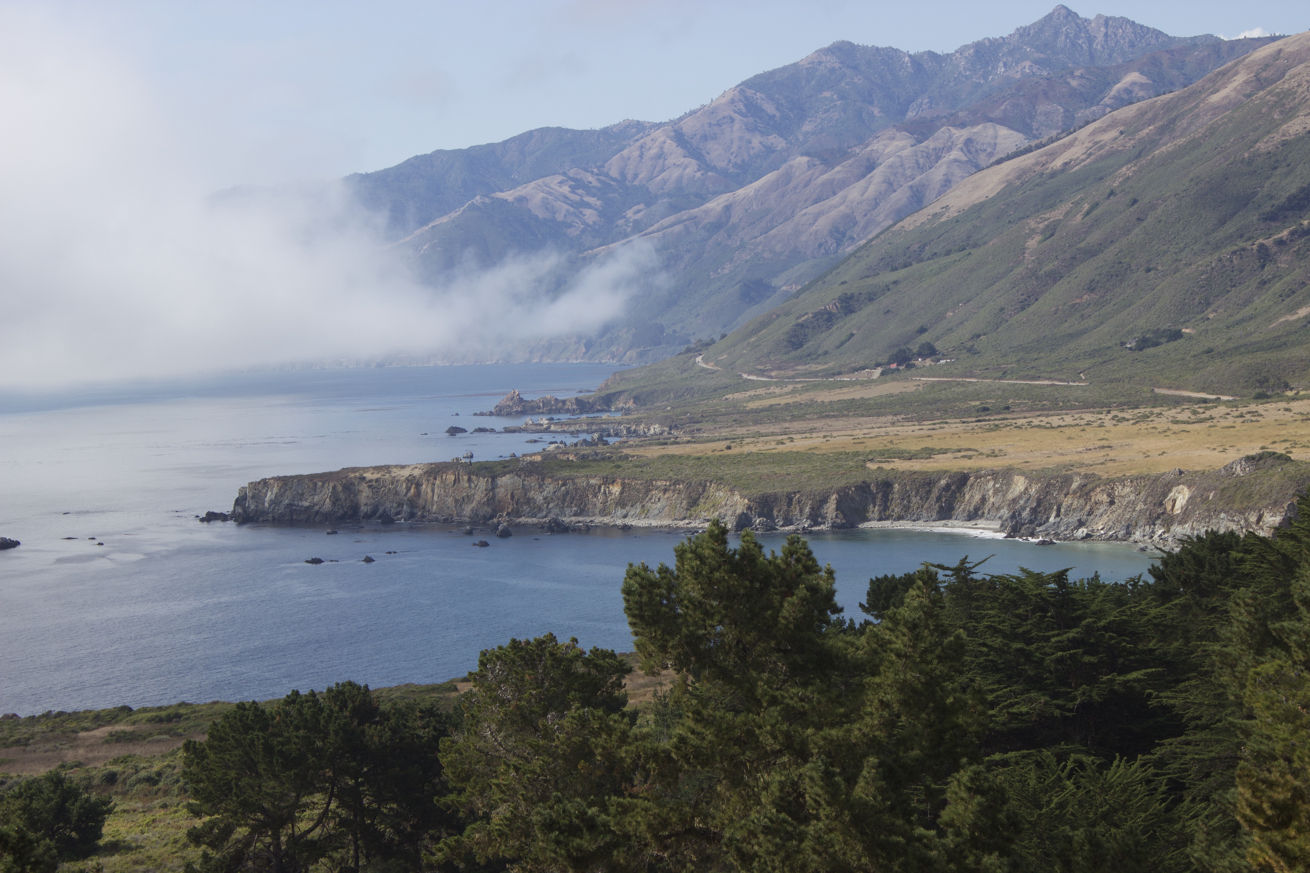 Rocky Big Sur coastline with cliffs dropping into the Pacific Ocean along Highway 1.