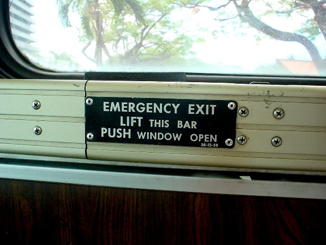 Operation guide metal plate for emergency exits installed in the school bus window.