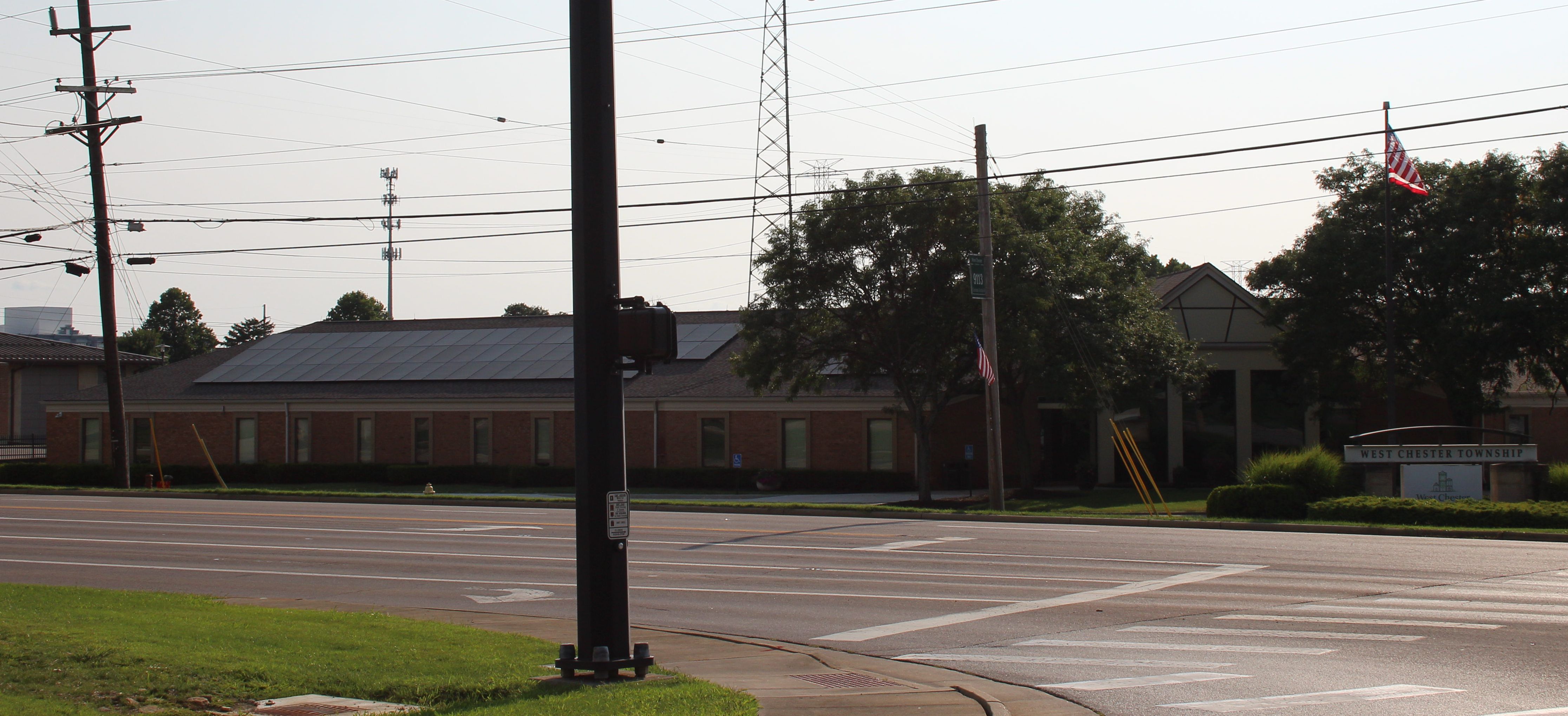 Single-story brick township administration building with American flag out front.