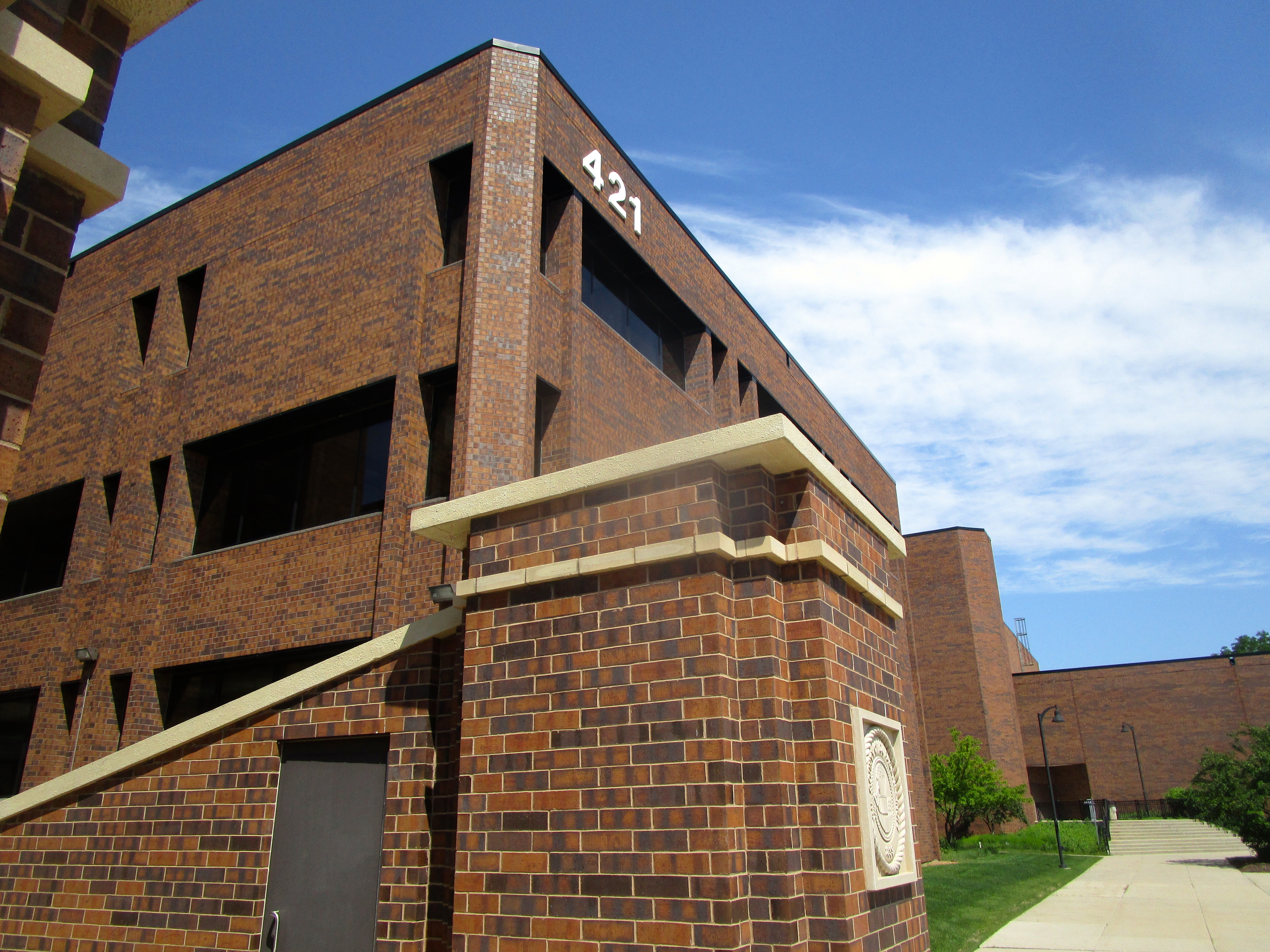 Exterior of the red brick DuPage County Administration Building with the number 421 on its facade.