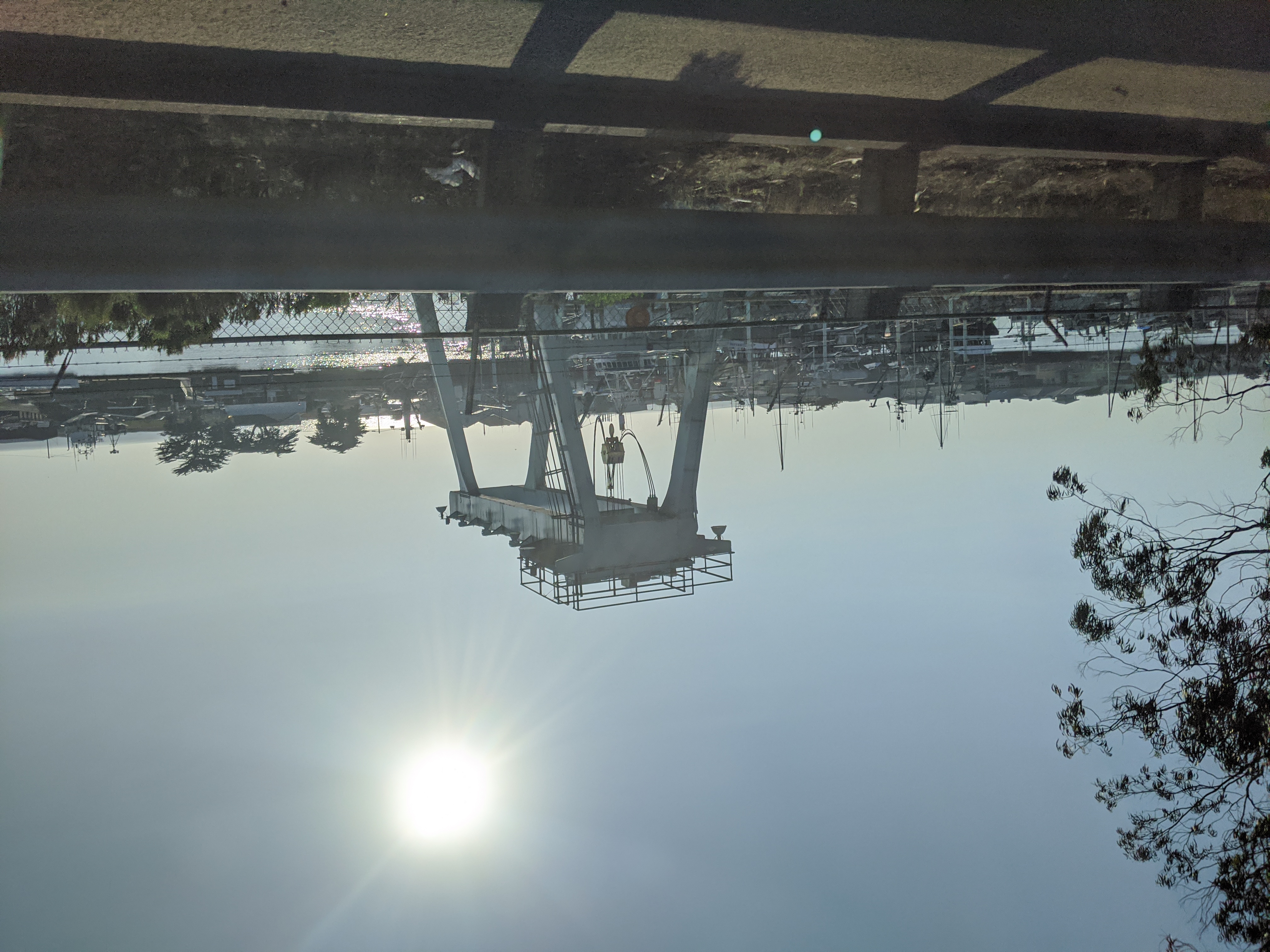 Harbor with a large boat hoist structure and marina visible in the background.