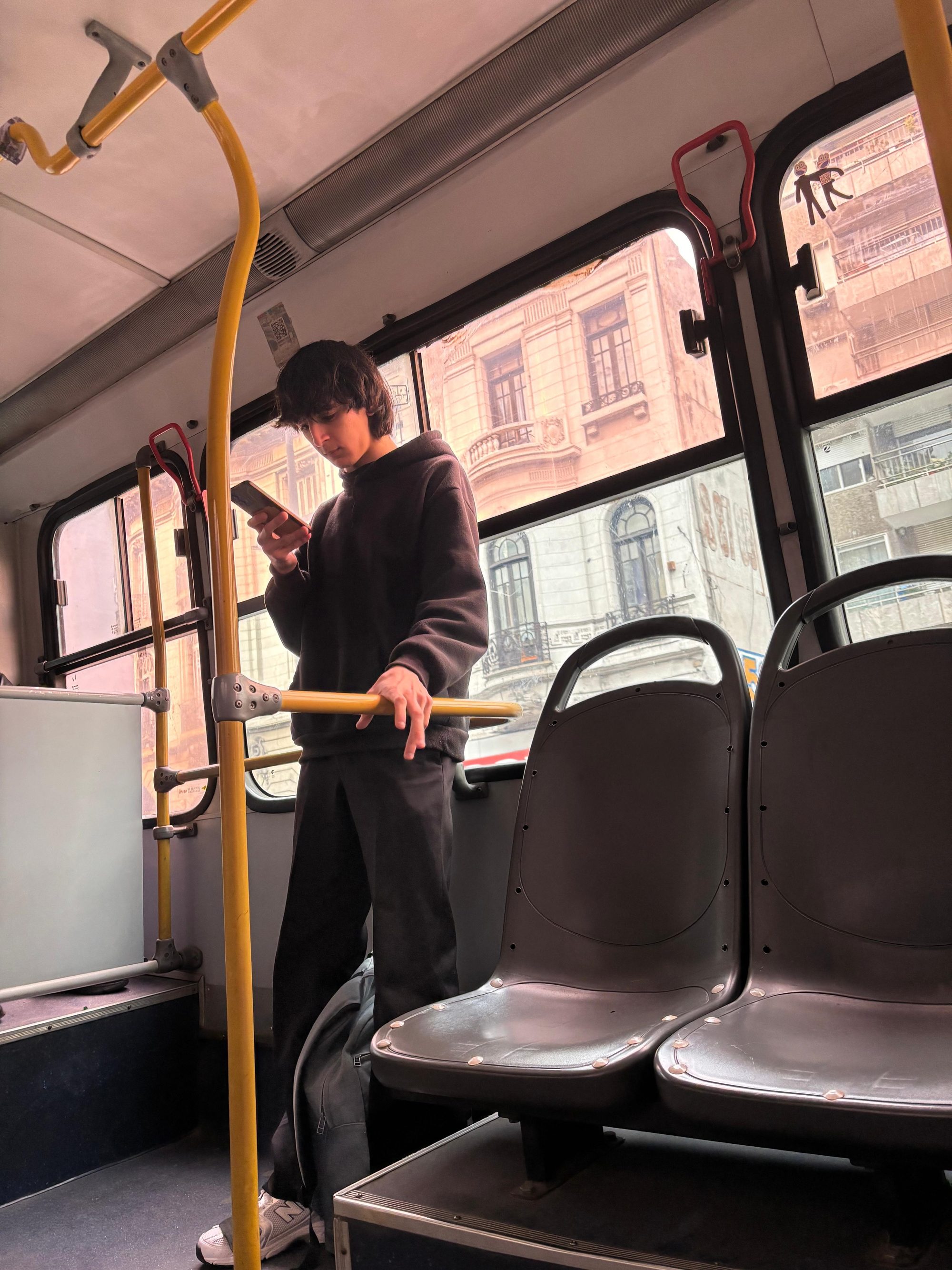 A teen boy from Uruguay with his smarthphone on board a bus in Montevideo.