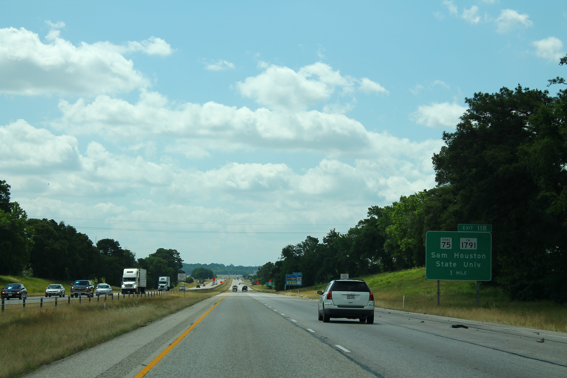 Multi-lane I-45 South highway with green overhead exit signs and vehicles ahead.