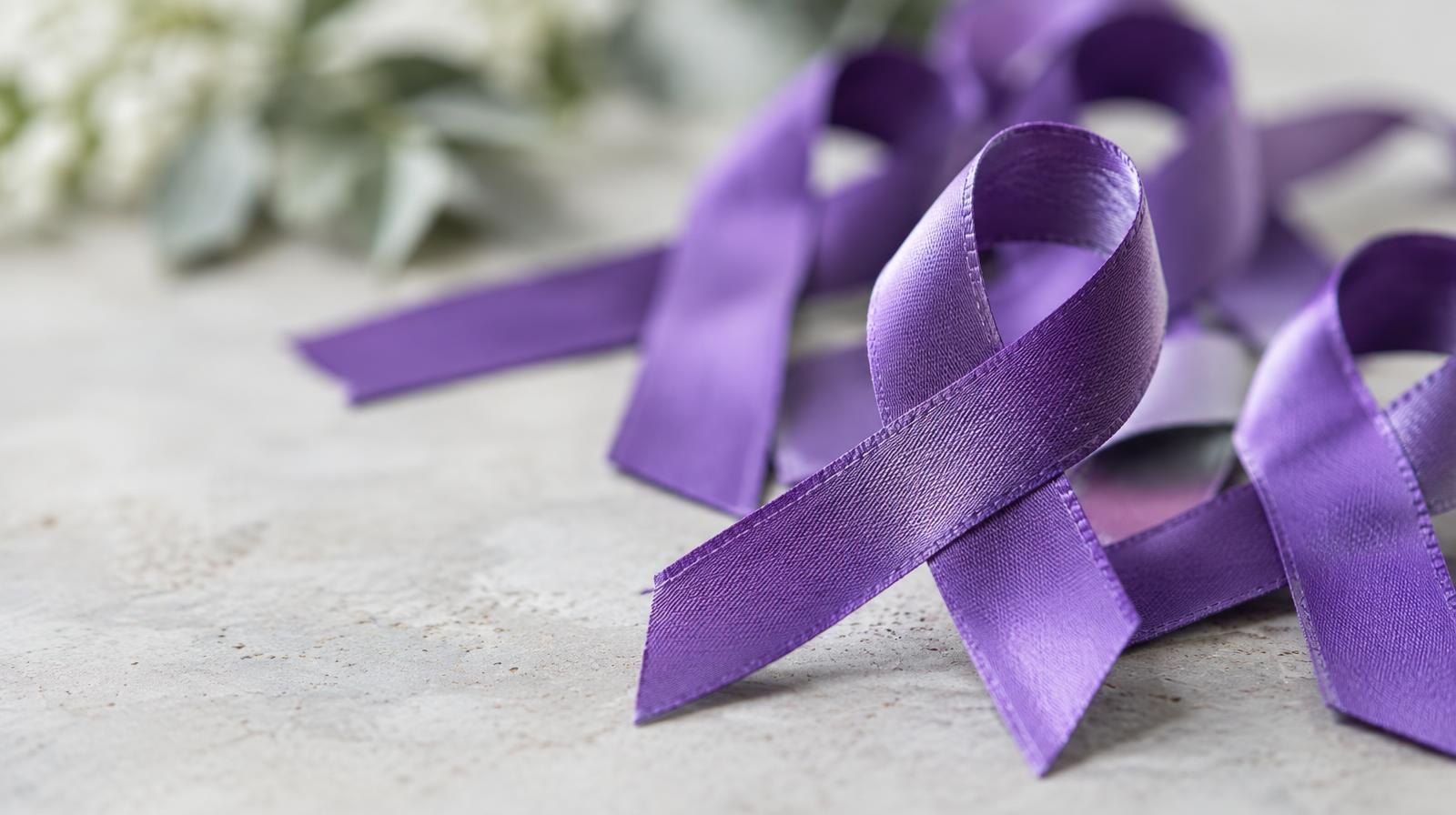 A cluster of purple awareness ribbons resting on a plain surface.