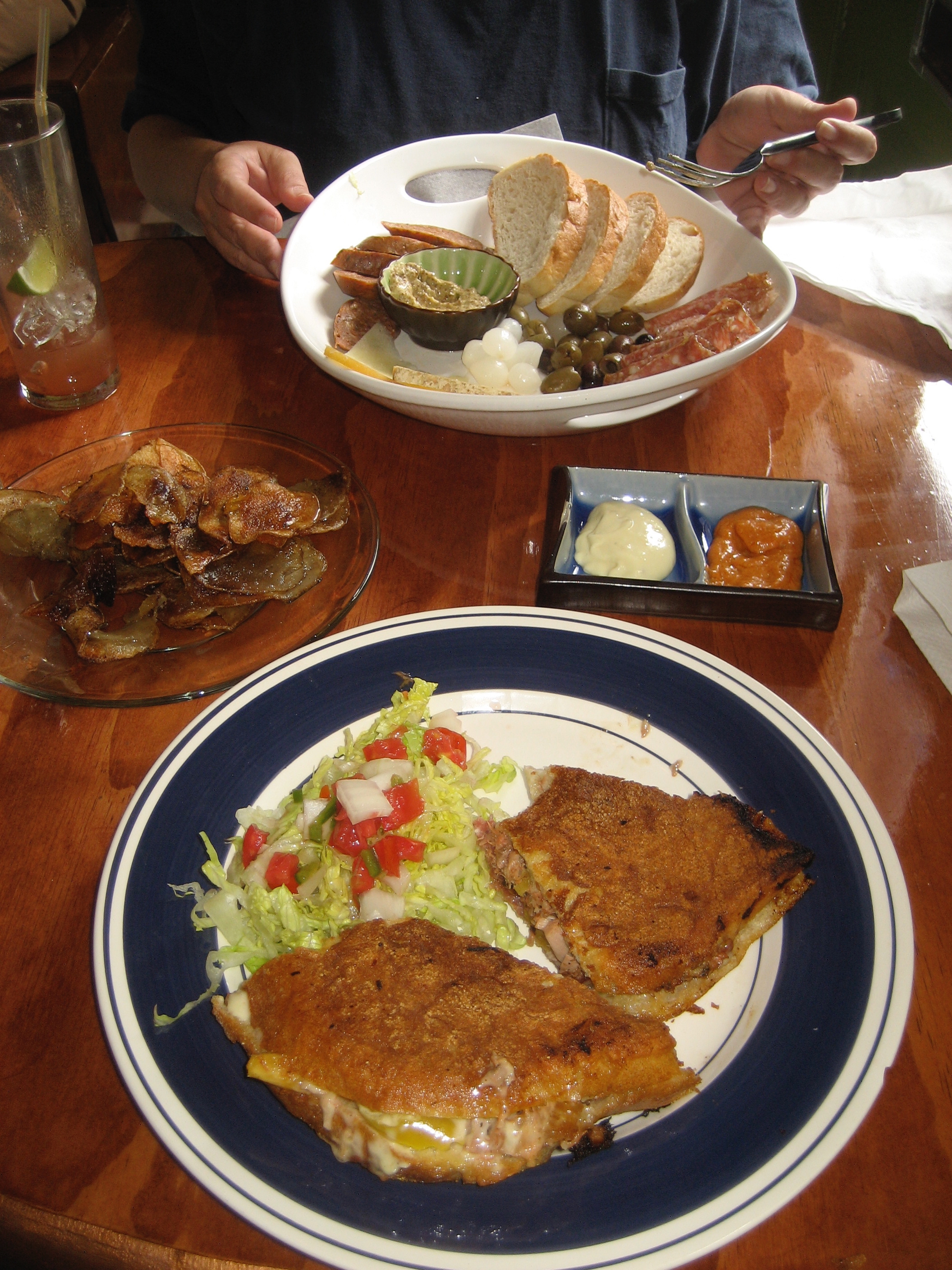 A plate with a sandwich and side salad on a restaurant table.