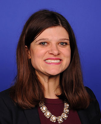 Woman in dark blazer smiling in an official congressional portrait.
