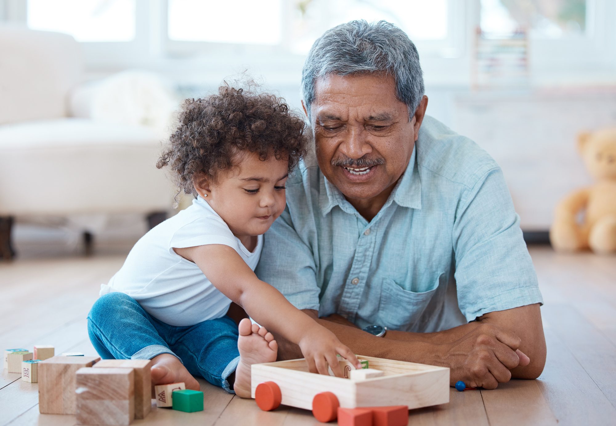 Shot of a little girl playing with her grandfather at home
