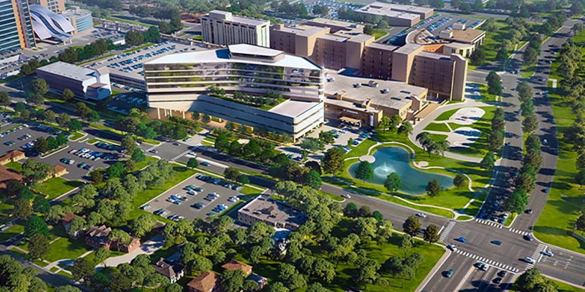 Aerial view of a large medical campus with multi-story hospital buildings and parking lots.