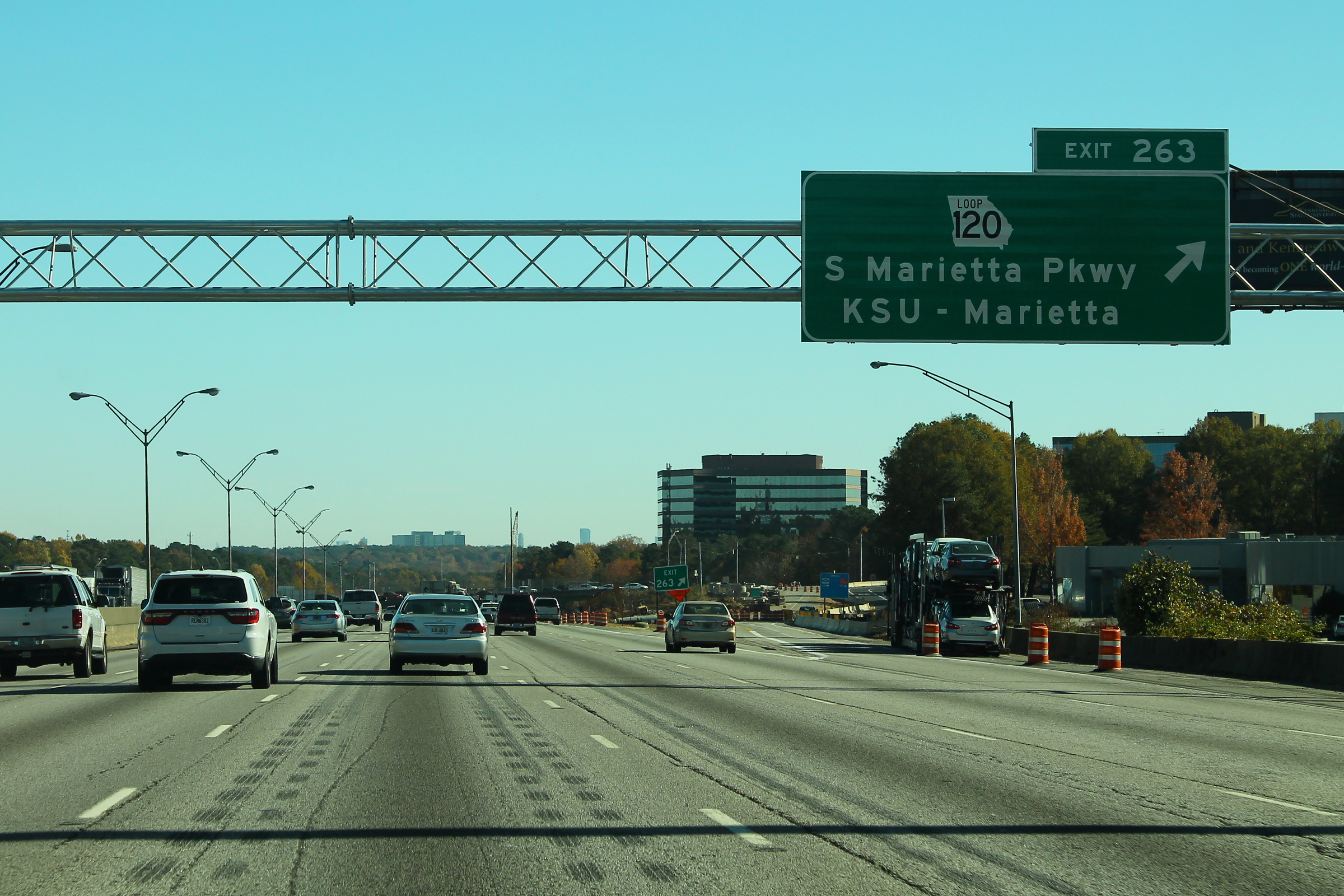 Multi-lane interstate highway with a green overhead exit sign and light traffic.