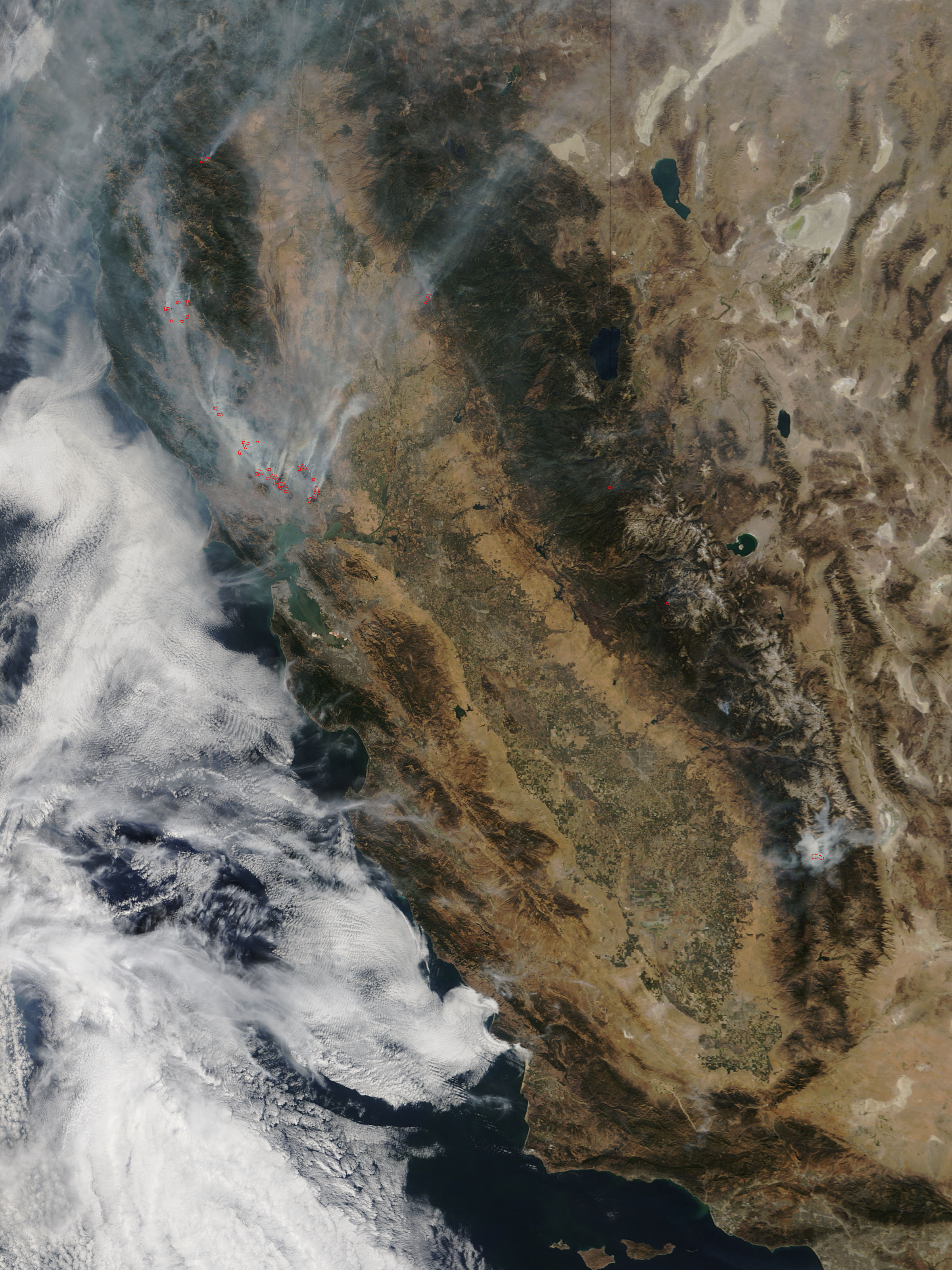 Satellite view of Northern California with smoke plumes and red-outlined fire hot spots.