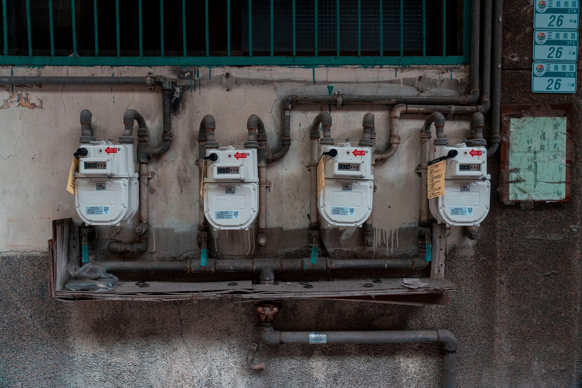 Four gas meters mounted on an exterior wall, showcasing urban utility infrastructure.