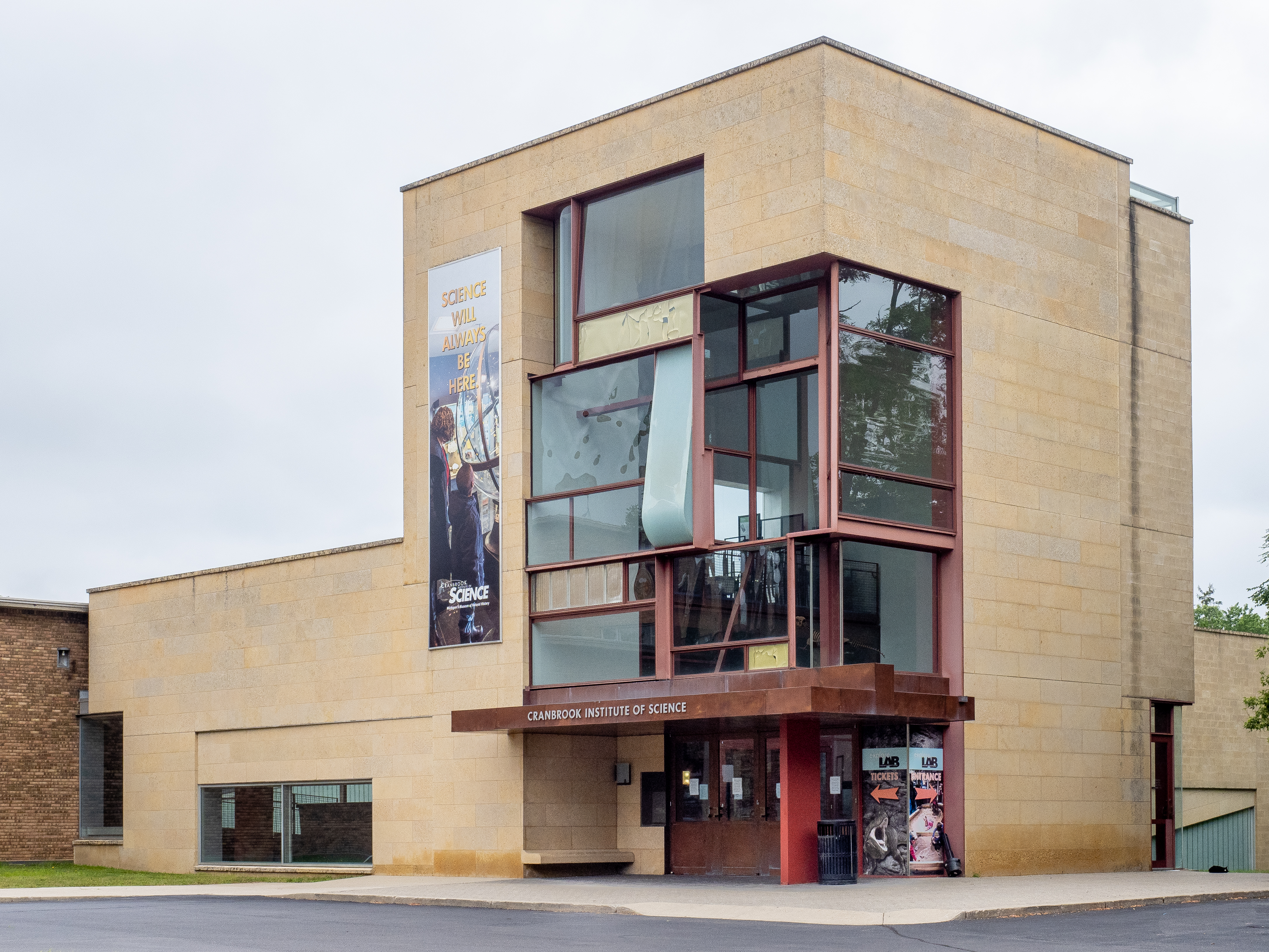 Exterior of the Cranbrook Institute of Science building with limestone facade and glass entrance tower.