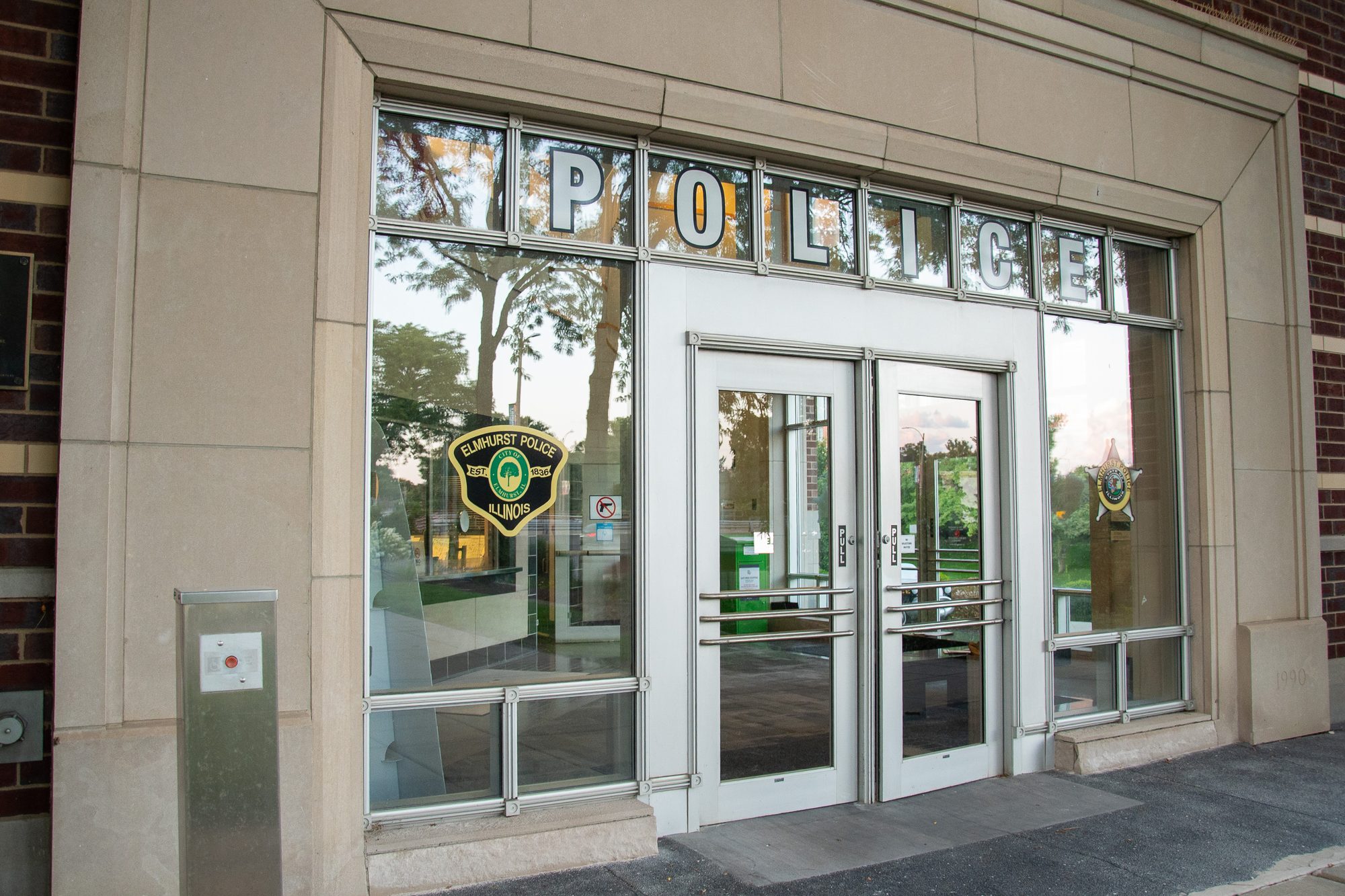 Glass entrance doors of a police station with the word Police spelled out above.