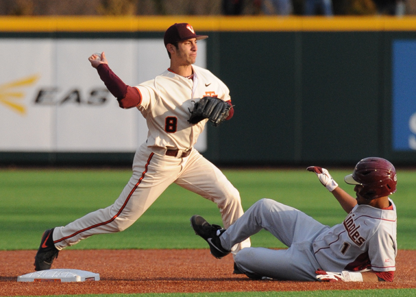 A baserunner in gray uniform slides into second base as an infielder throws the ball.